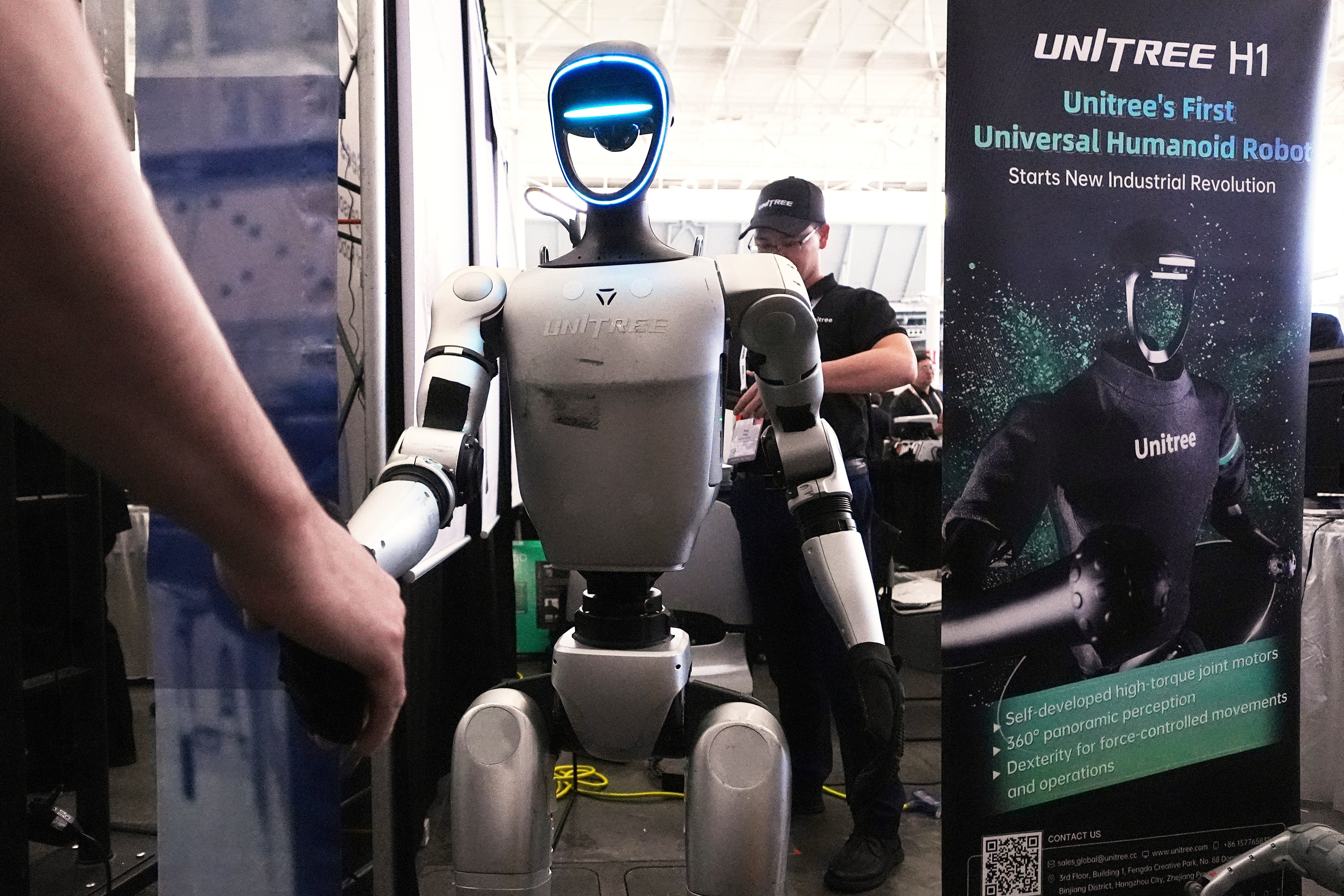 A Unitree robot shakes hands with a convention guest at the Robotics Summit & Expo, April 30, 2025, in Boston. Photo: AP