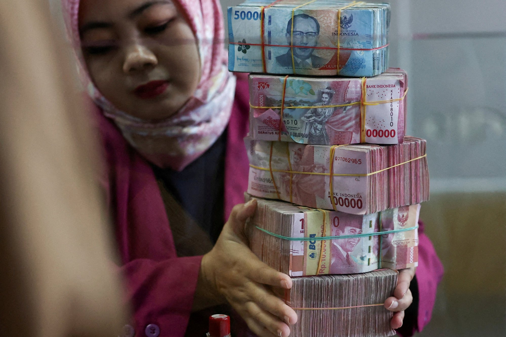 A cashier prepares Indonesian rupiah banknotes at a money changer in Jakarta. Photo: Reuters A cashier prepares Indonesian rupiah banknotes at a money changer in Jakarta. Photo: Reuters