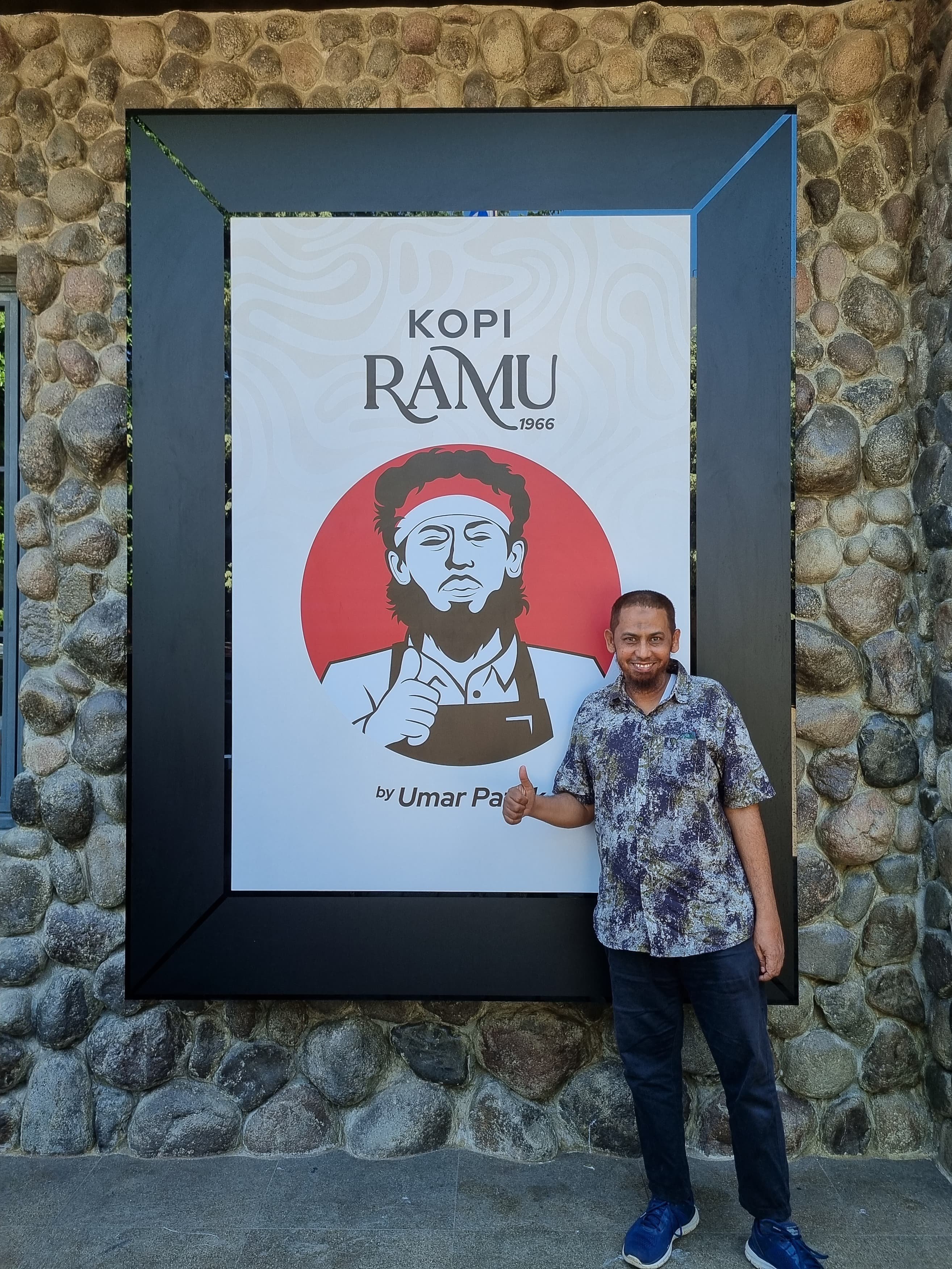Convicted Bali bomber Umar Patek with a poster advertising his new coffee business in Indonesia. Photo: Aisyah Llewellyn