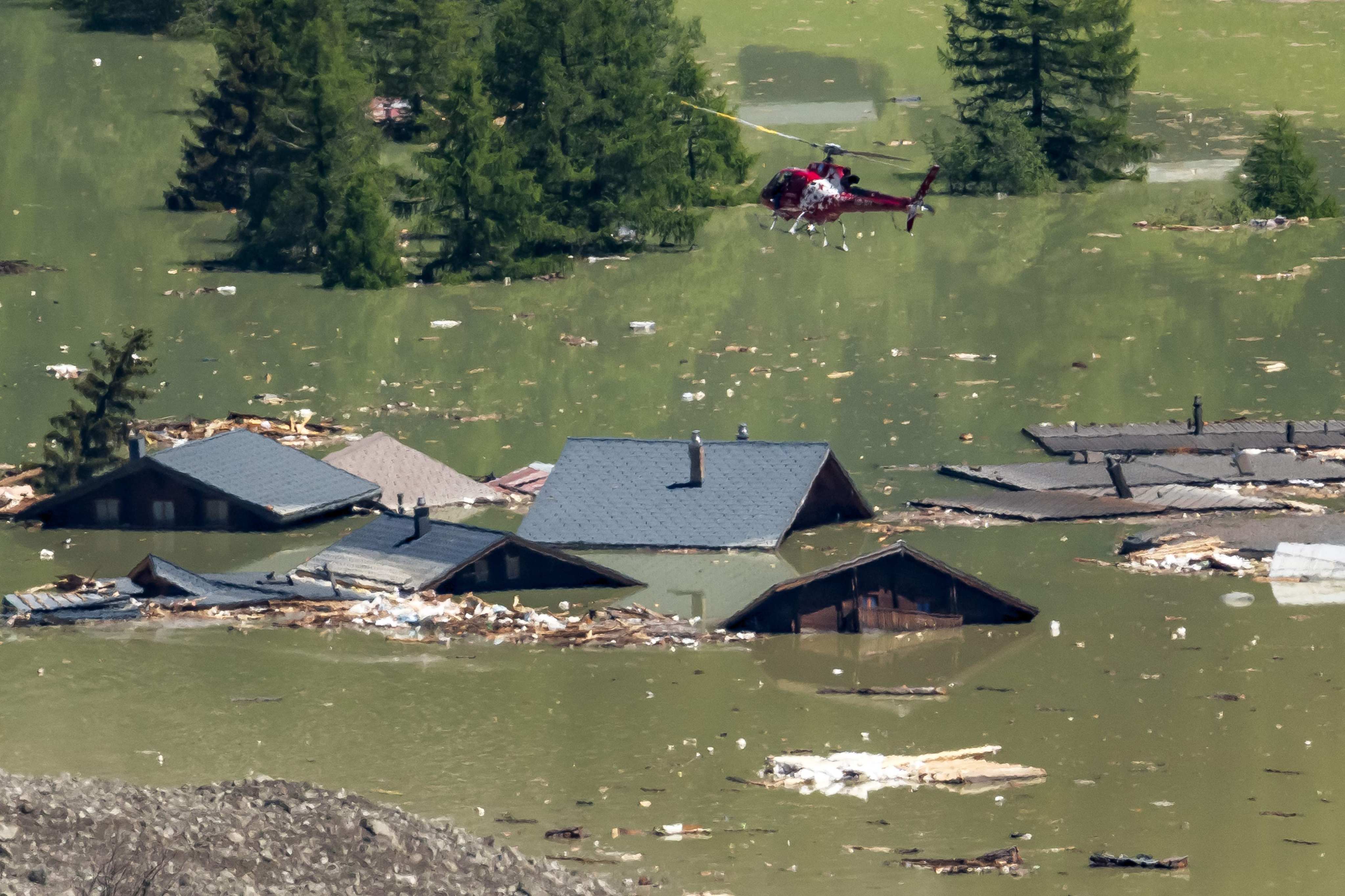 A helicopter flies above debris and destroyed houses of the village of Blatten now submerged after the huge Birch glacier collapsed on Wednesday. Photo: AFP