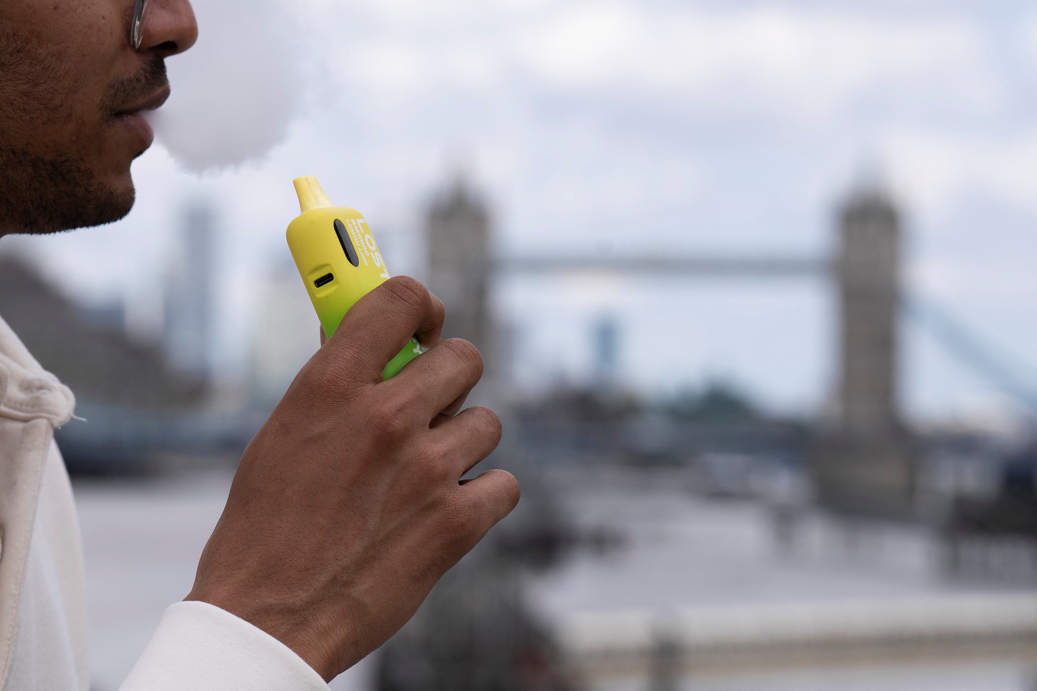 A man holds a disposable vape near London Bridge on Friday. Photo: Reuters
