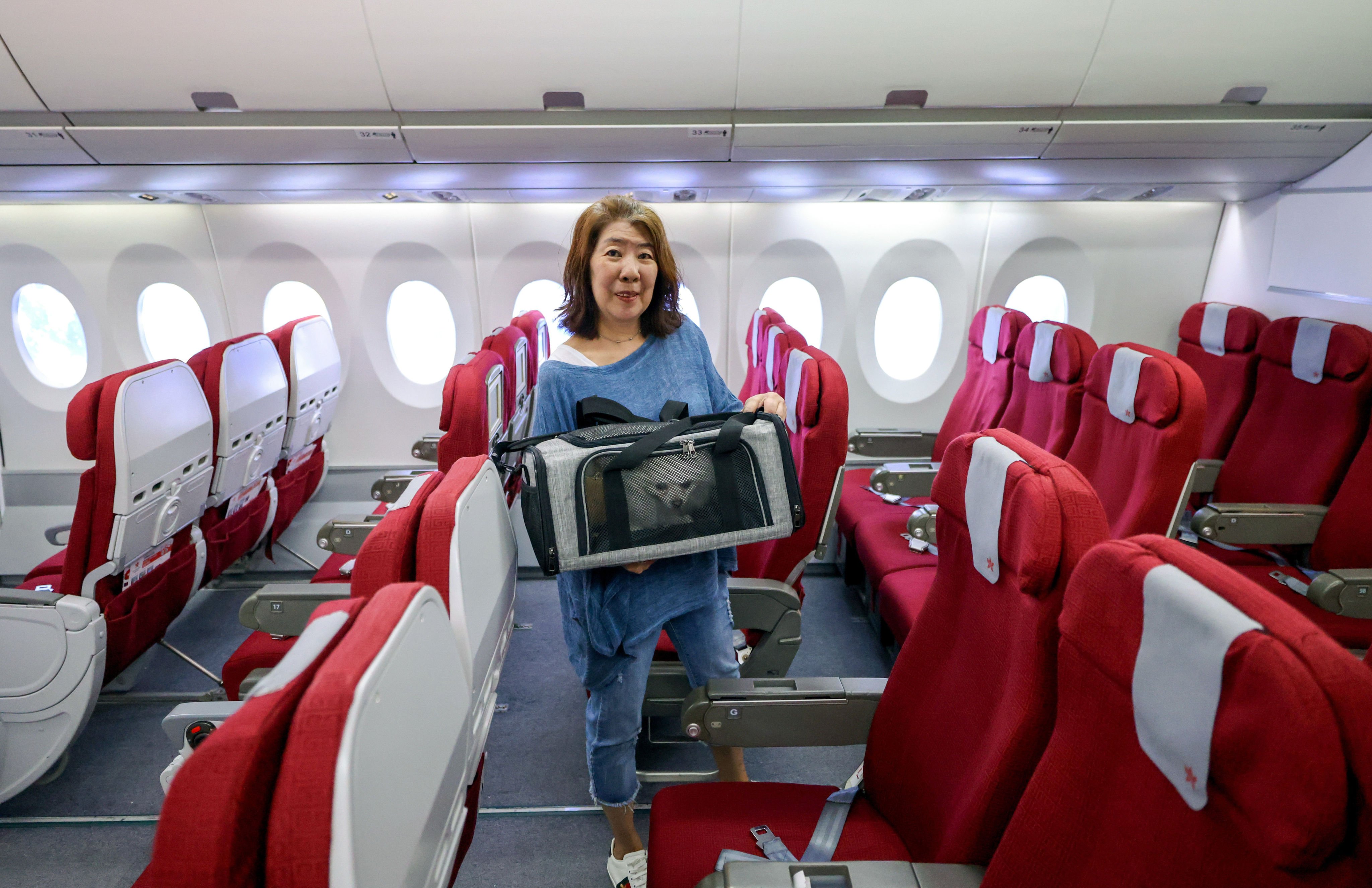 Hong Kong Airlines customer Yolly Chan, with her dogs Bub and Cobbie in a bag, says she would recommend carrier’s the pet-in-cabin service to friends. Photo: Nora Tam