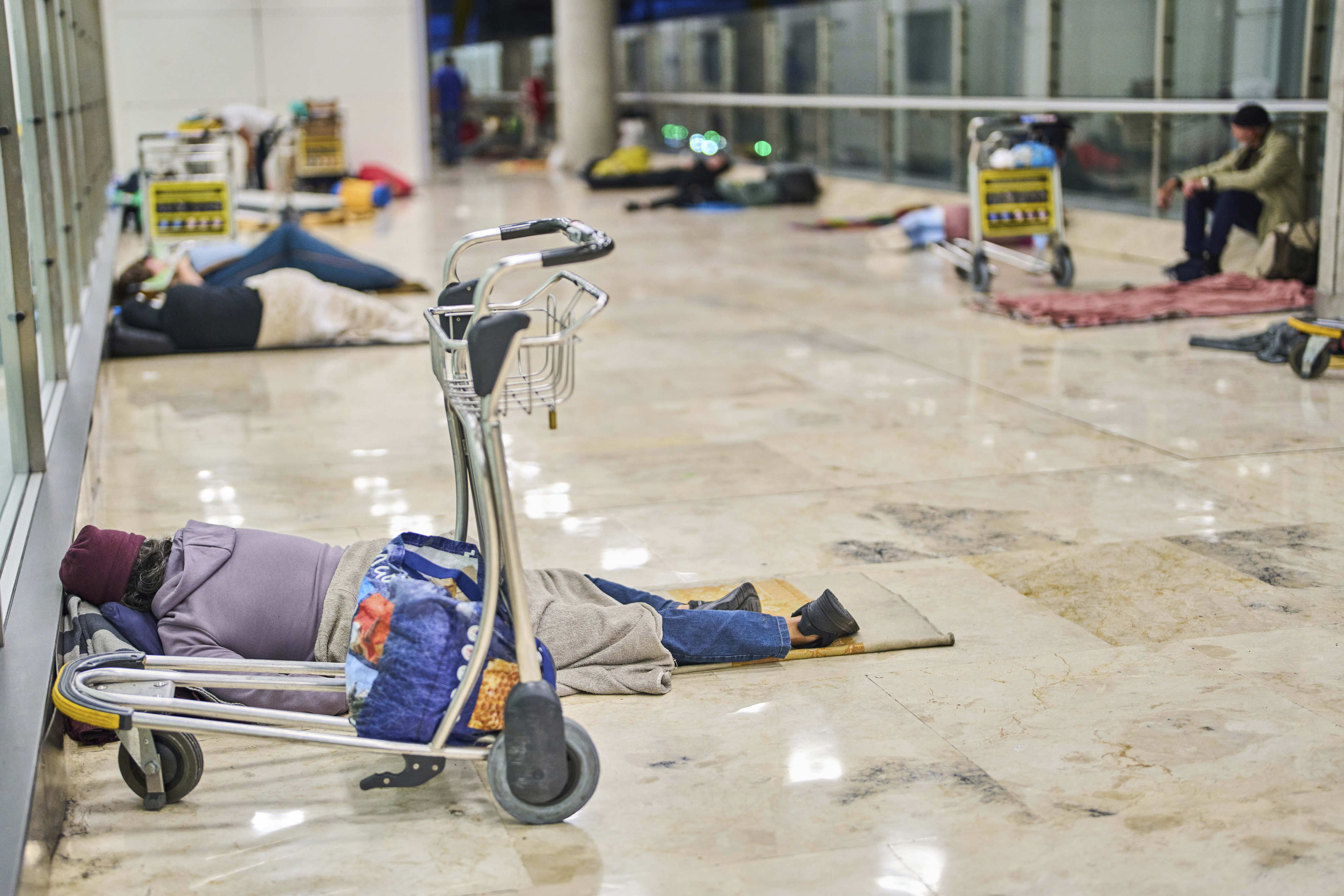People sleep on the floor of Terminal 4 at Adolfo Suarez-Madrid Barajas Airport in Madrid, Spain. Photo: AP