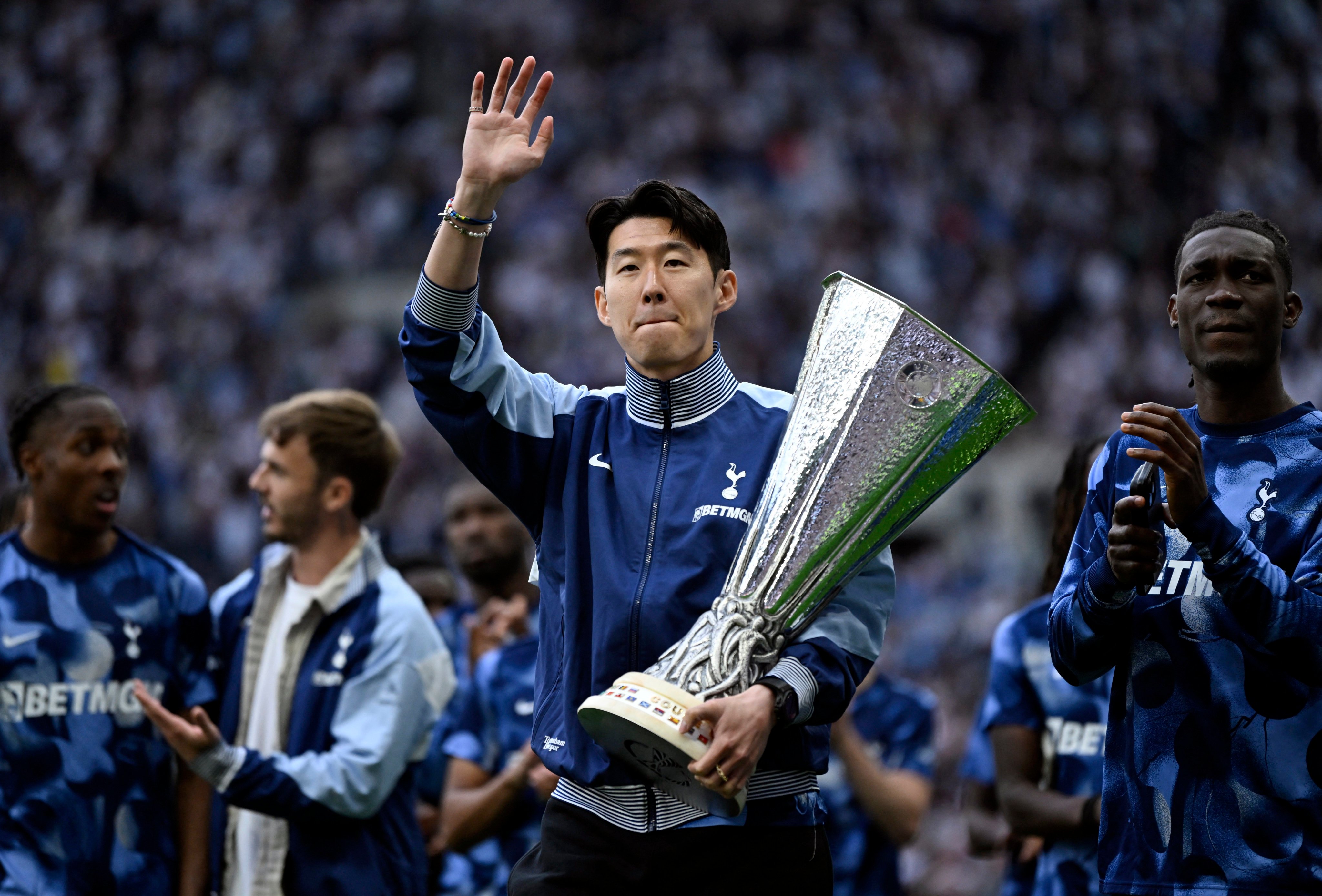 Son Heung-min holds the Europa League trophy as Tottenham Hotspur players celebrate their triumph with their supporters. Photo: Reuters