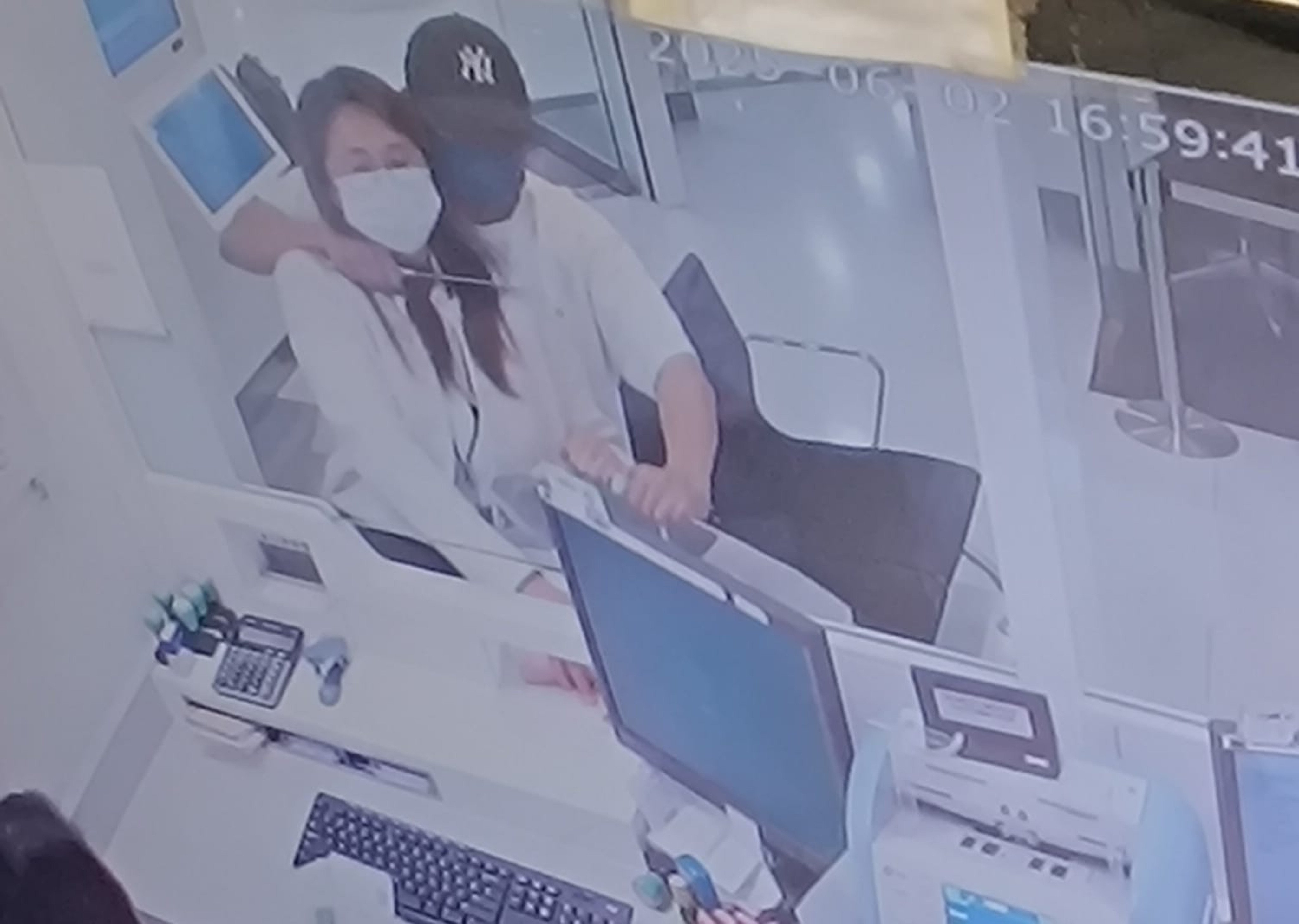 A screen grab of CCTV footage circulating online shows the robber holding a knife at the bank worker’s throat. Photo: Handout