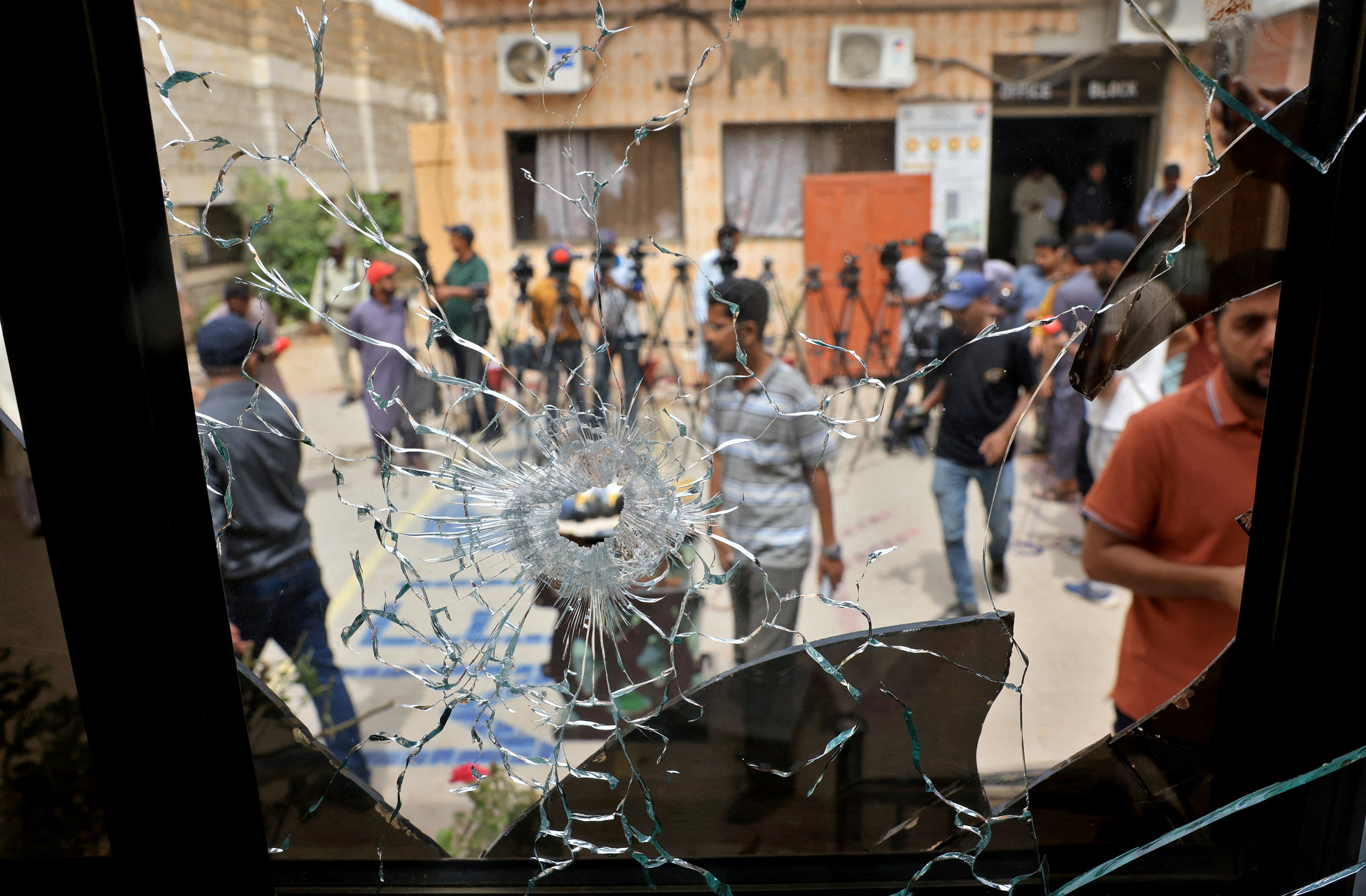 Members of media are seen through a broken glass window inside the premises of the district Malir jail after dozens of prisoners escaped from the jail on the outskirts of Karachi, Pakistan on June 3. Photo: Reuters