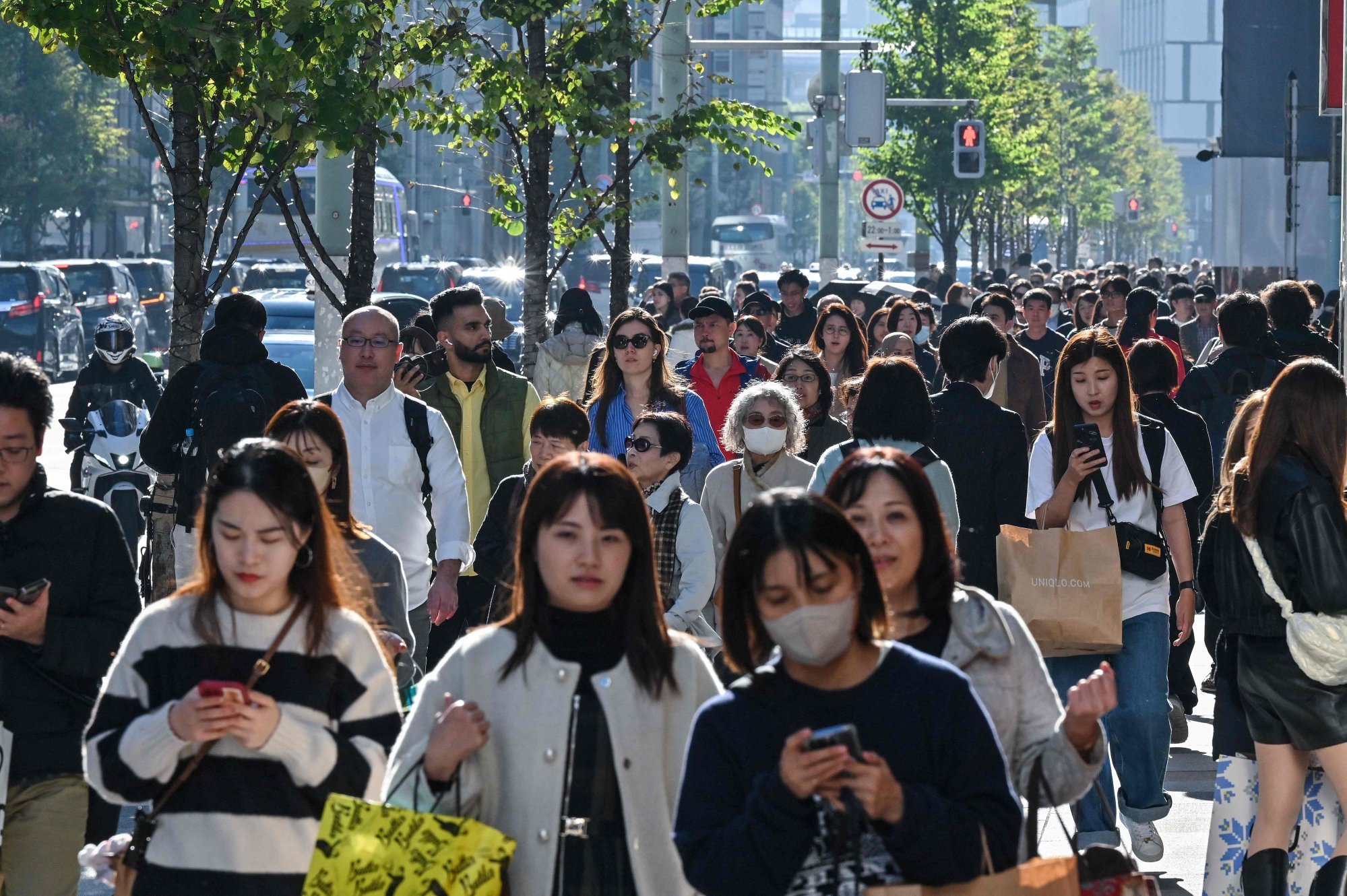Pedestrians walk down the high-street shopping area of the Ginza district in central Tokyo. Photo: AFP Pedestrians walk down the high-street shopping area of the Ginza district in central Tokyo. Photo: AFP