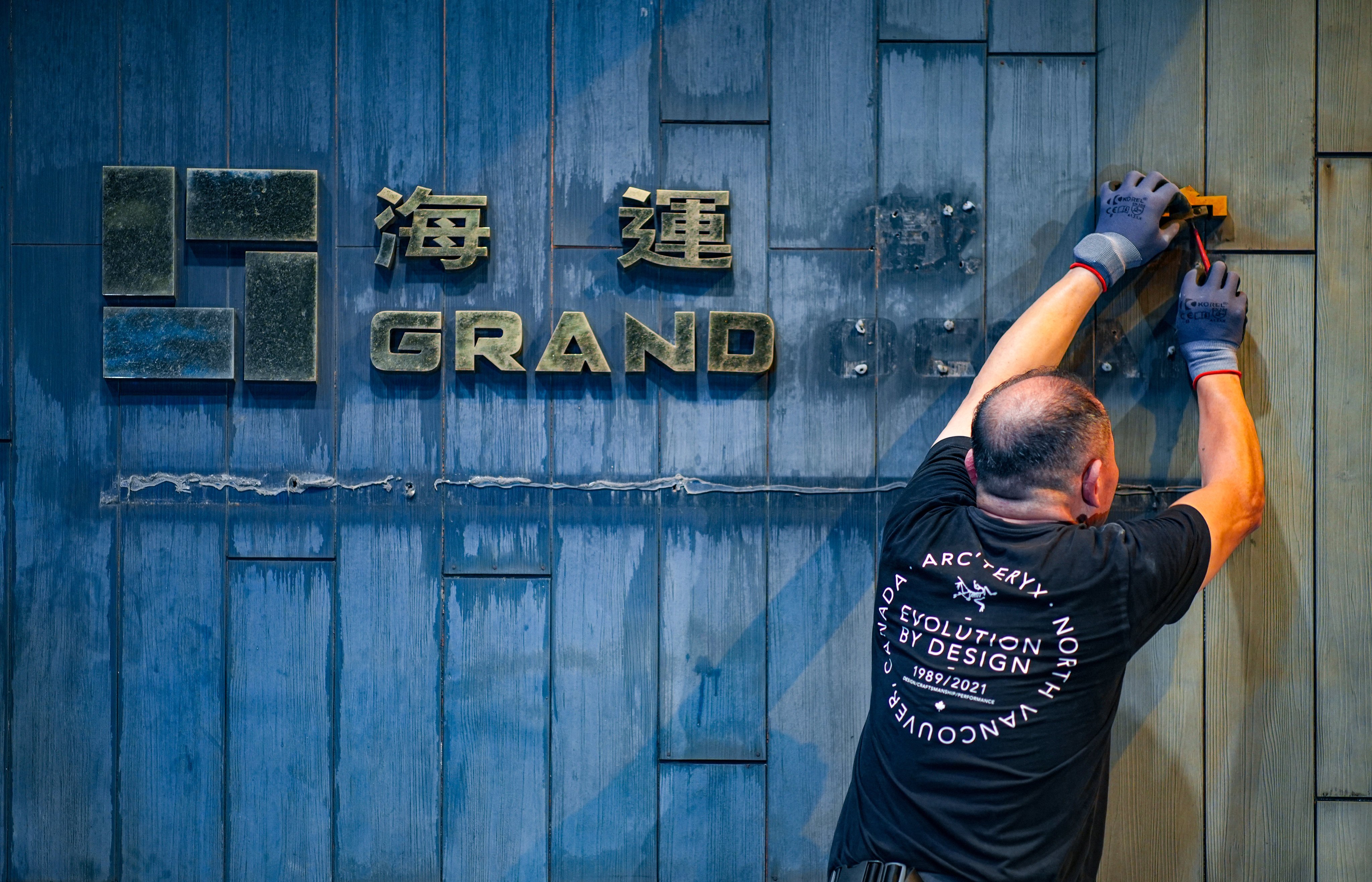 A worker takes down the logo of Grand Ocean cinema in Tsim Sha Tsui earlier this week. Photo: Eugene Lee