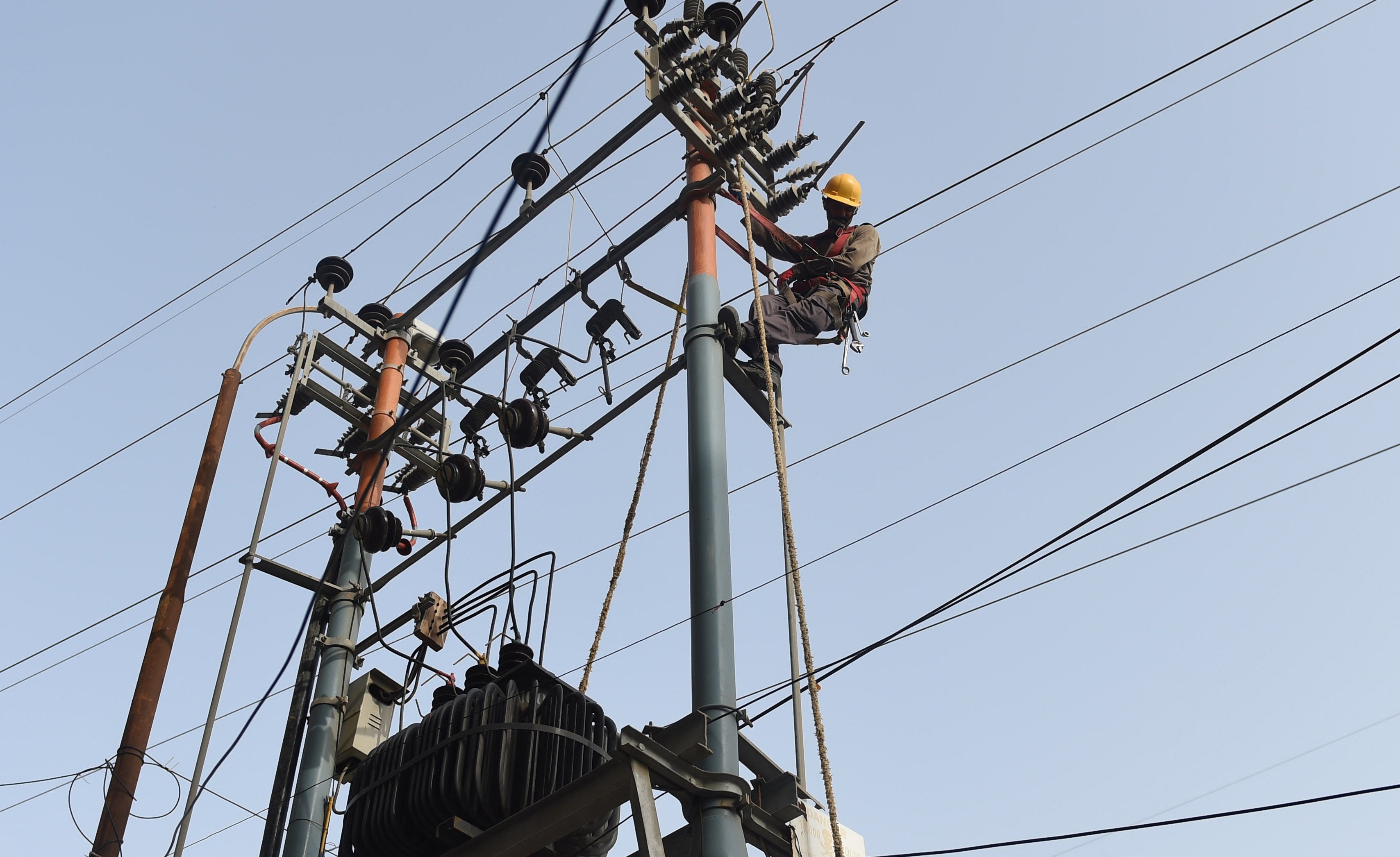 Karachi Electric Corporation technicians work on a high voltage line in Pakistan. Photo: AFP