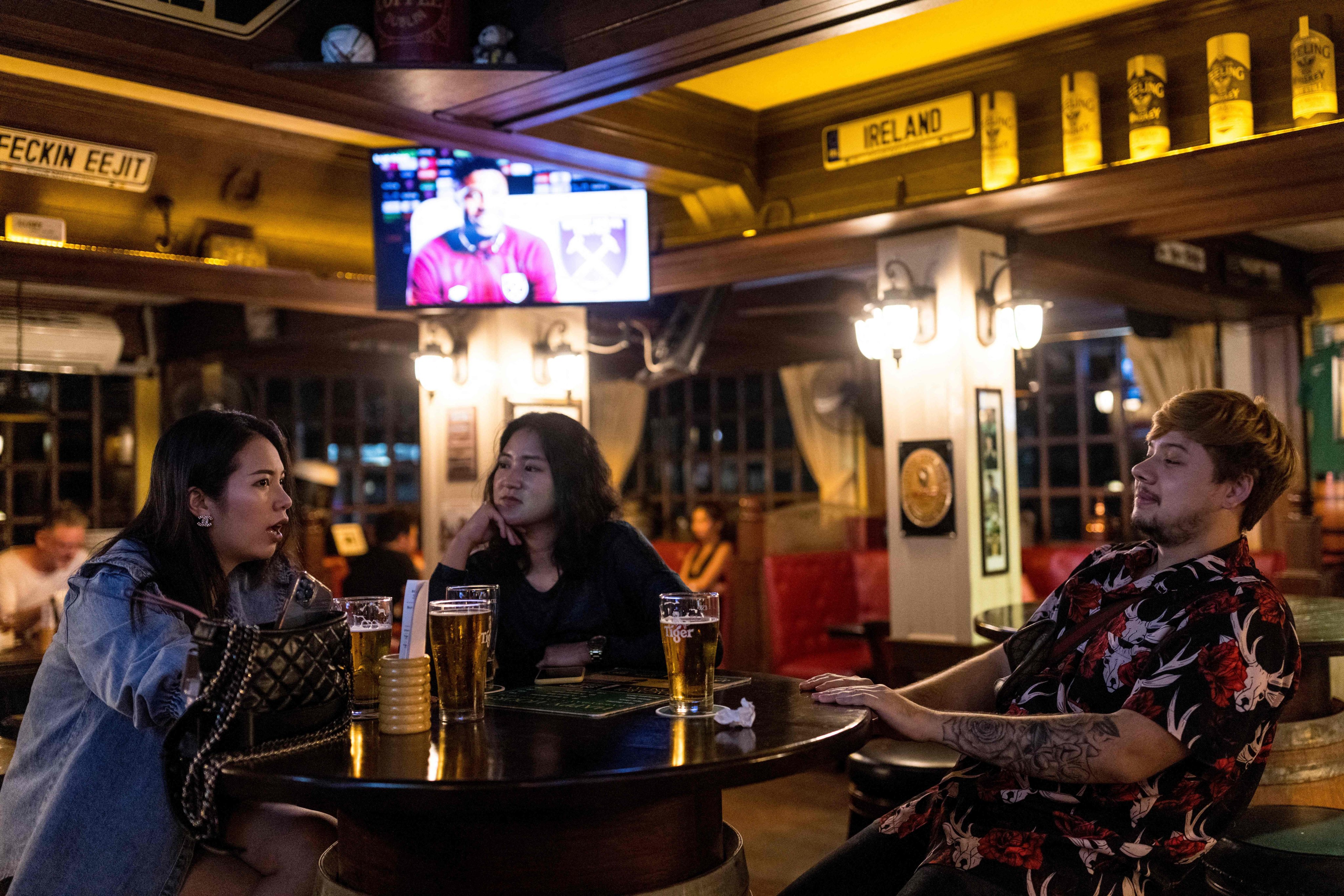 People enjoy drinks in a bar in Bangkok. A Thai teachers’ network has protested against a state agency’s partnership with a beer company to offer beer discounts for teachers. Photo: AFP