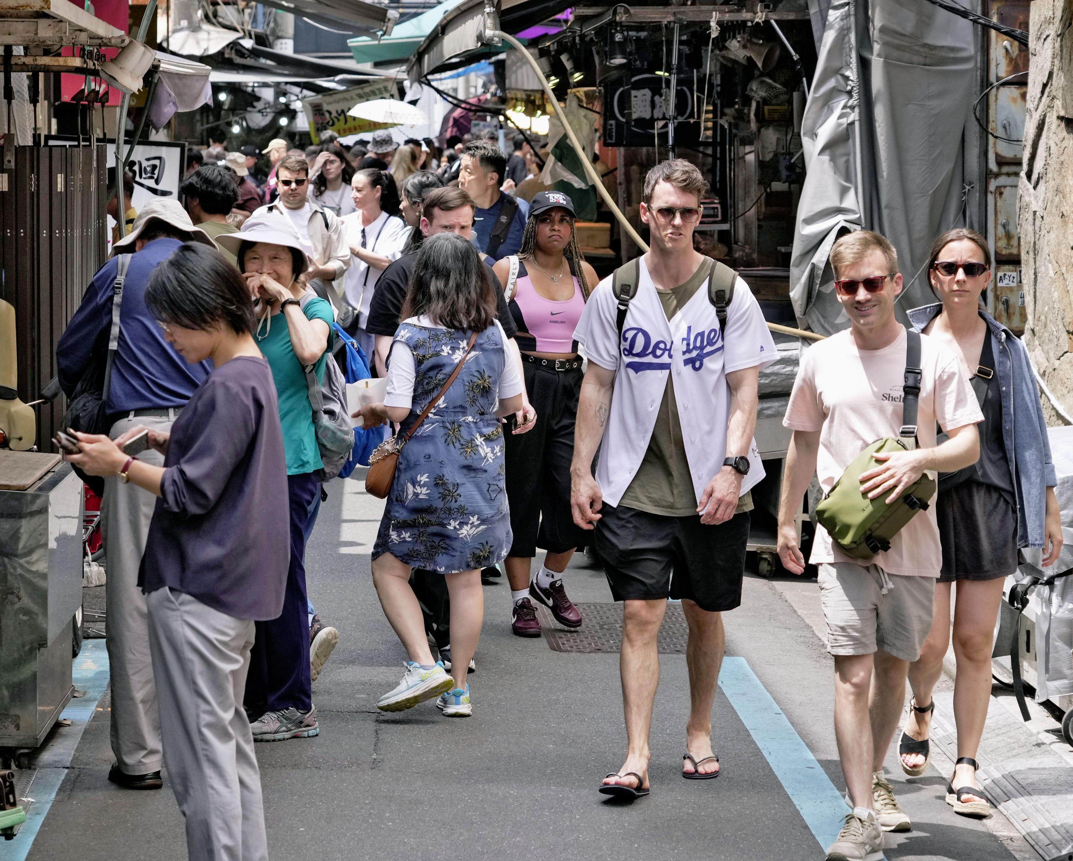 Foreign tourists walk in Tokyo’s Tsukiji area on May 21. Photo: Kyodo