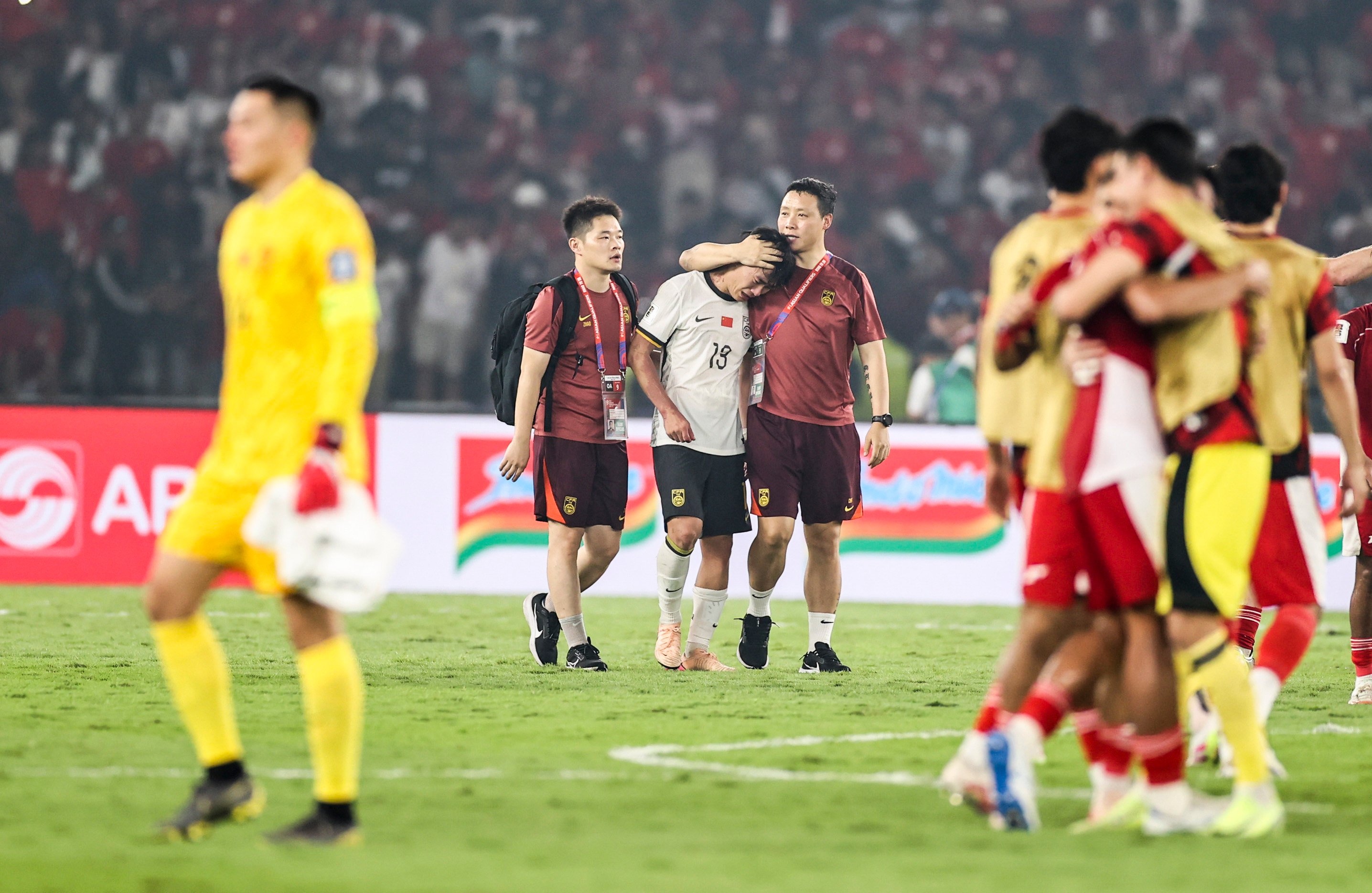 China full-back Hu Hetao (centre, rear) is consoled after defeat to Indonesia ended their hopes of reaching the 2026 World Cup finals. Photo: Xinhua