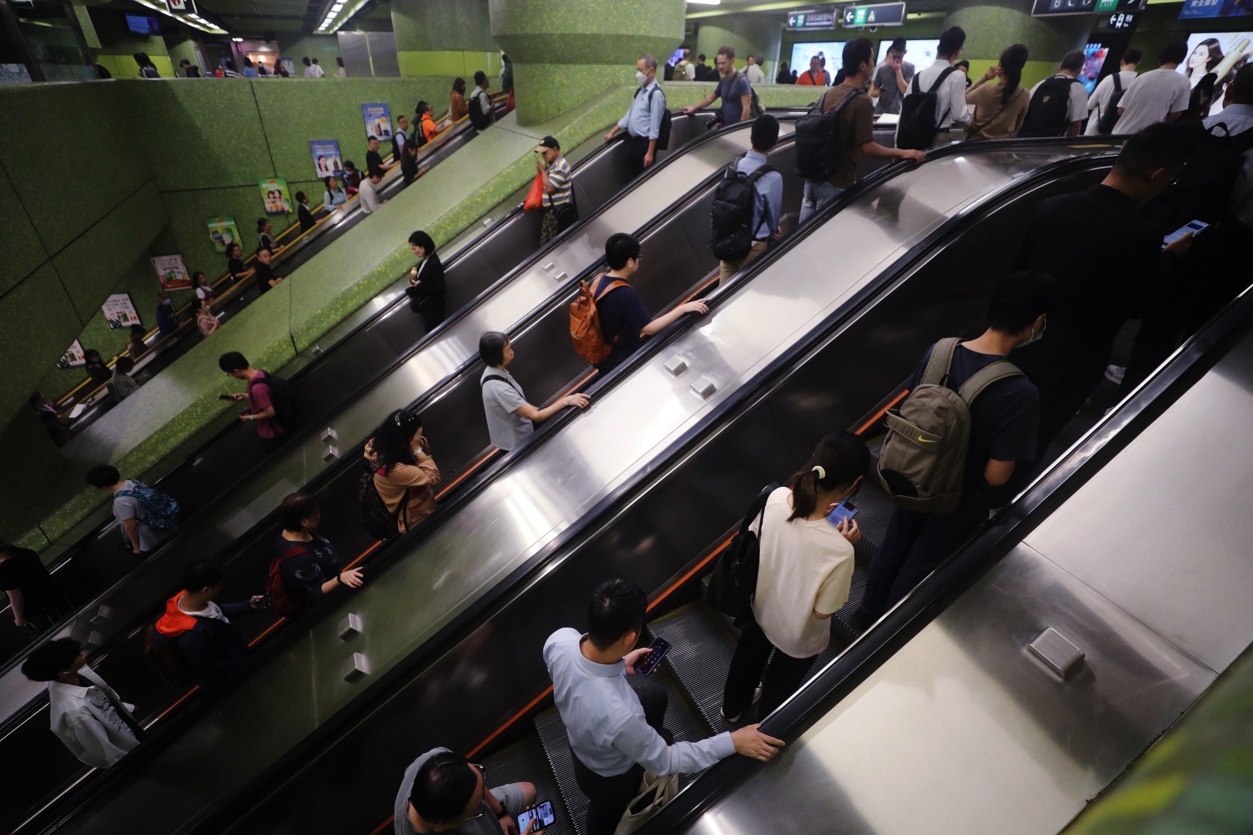 Commuters hold on to escalator handrails, or their phones, in Wan Chai MTR station on November 14. Photo: Sun Yeung