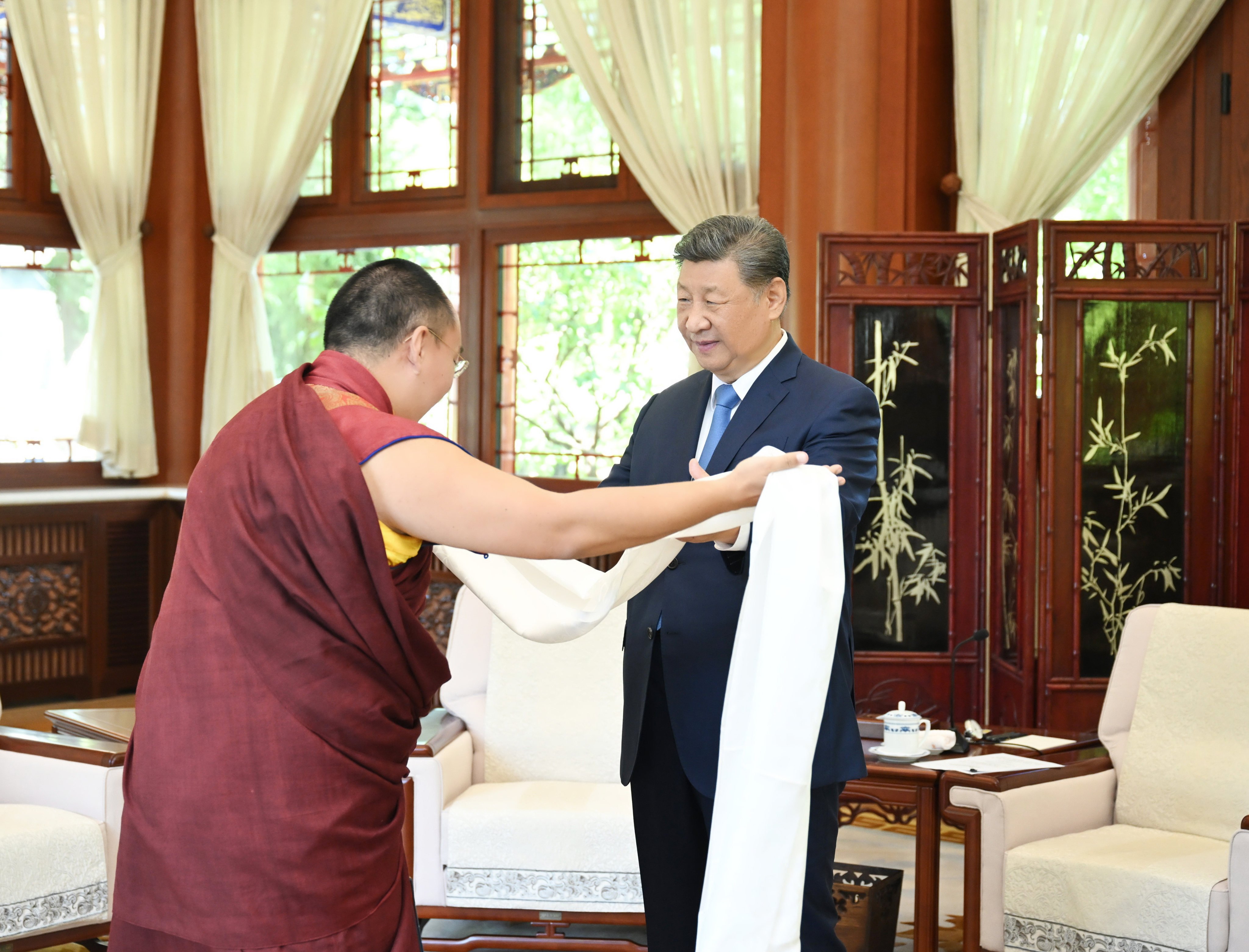 The 11th Panchen Lama presents a traditional Tibetan ceremonial scarf to President Xi Jinping as they meet in Beijing on Friday. Photo: Xinhua