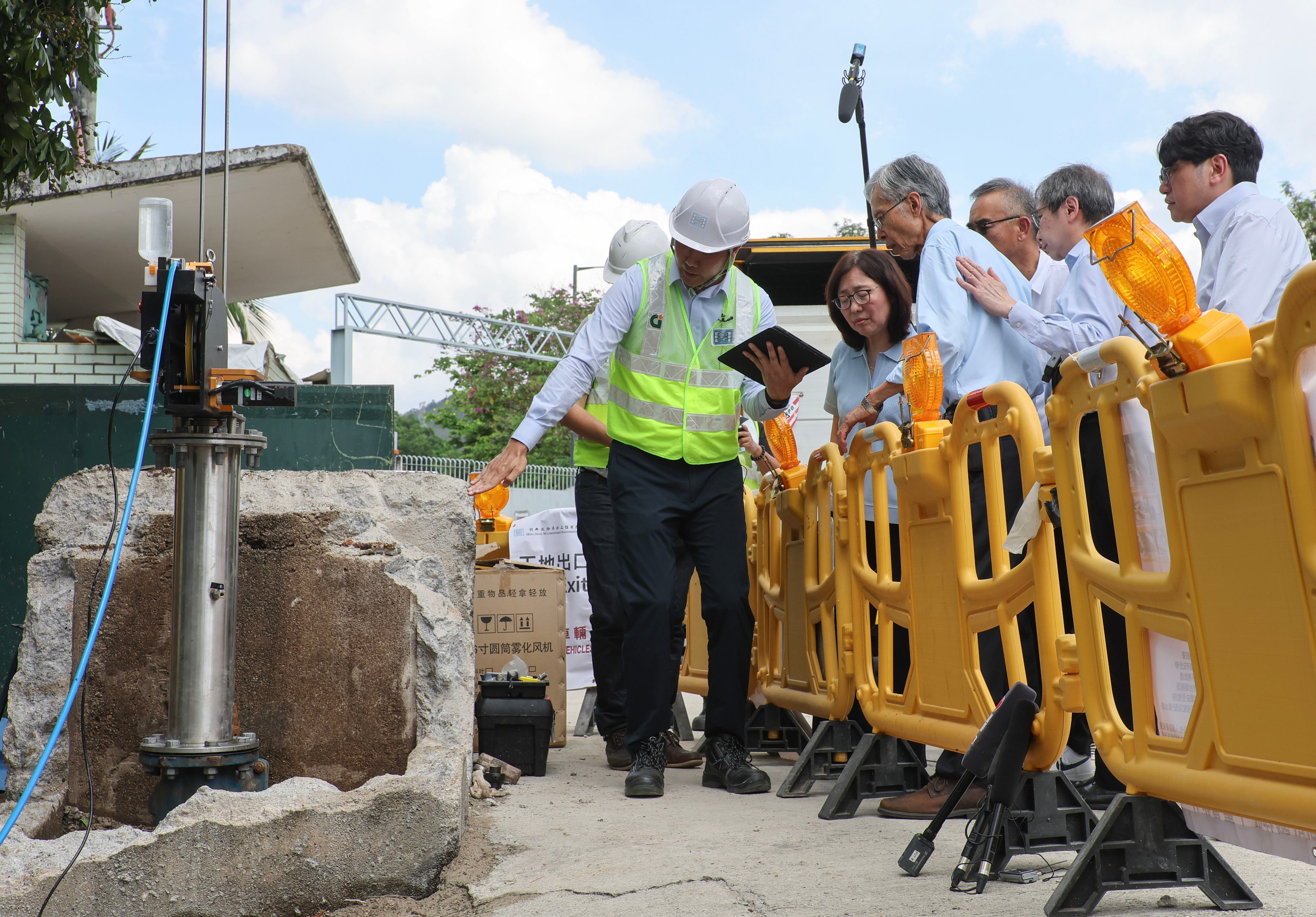 Government officials visit workers checking water pipes. The city has about 700km of pipes lined with bitumen. Photo: Edmond So