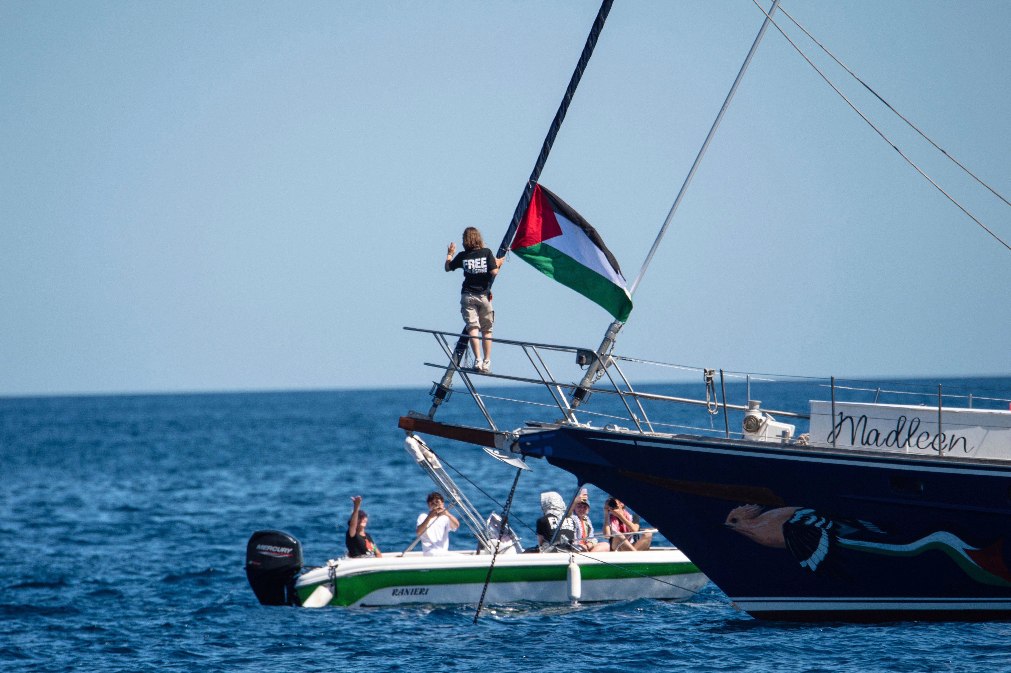 Climate activist Greta Thunberg stands near a Palestinian flag after boarding the Madleen boat and before setting sail for Gaza along with activists of the Freedom Flotilla Coalition, departing from the Sicilian port of Catania, Italy, on June 1. Photo: AP