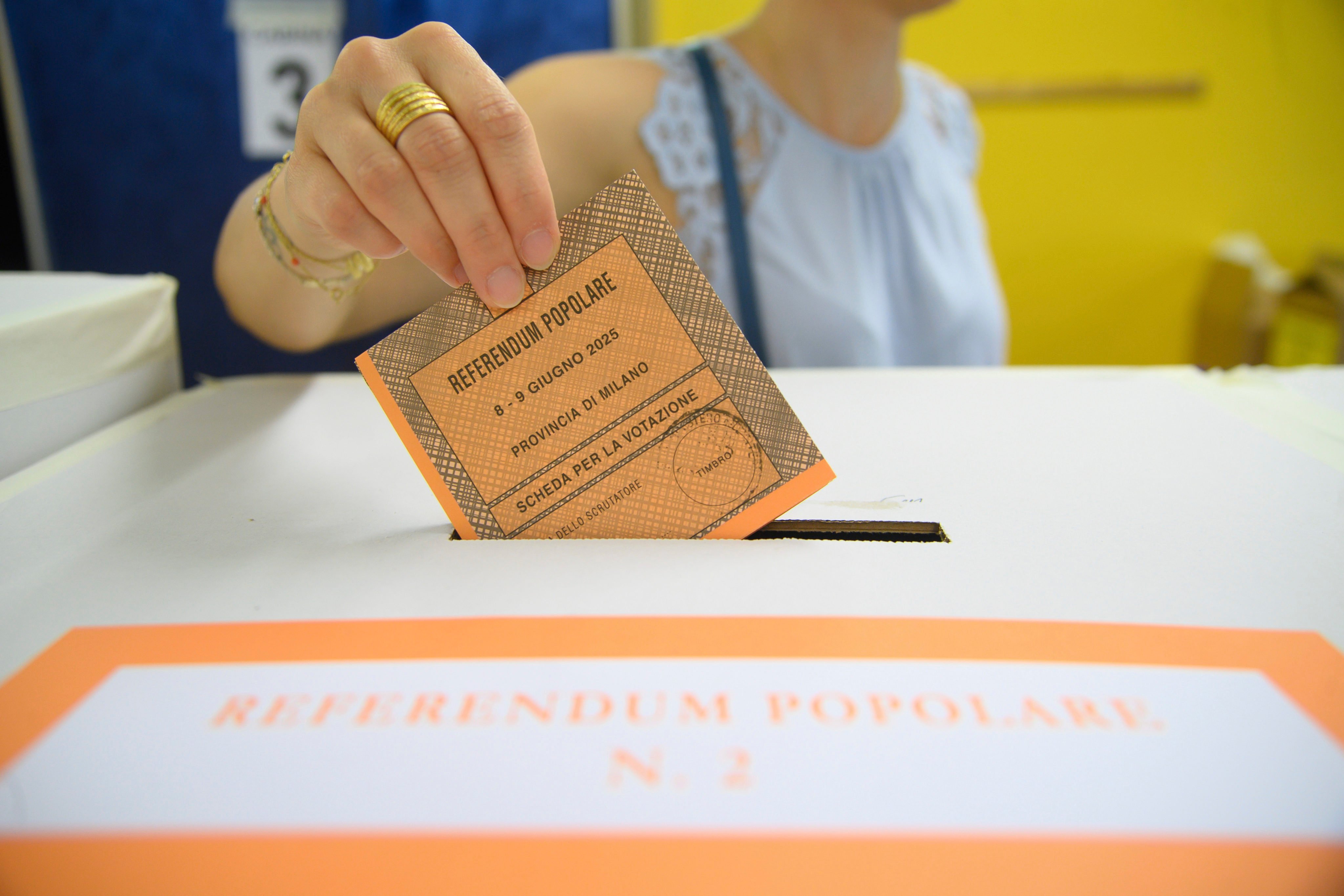 A woman casts her ballot in a box for referendums on citizenship and job protections, at a polling station in Milan, Italy, on Sunday. Photo: AP