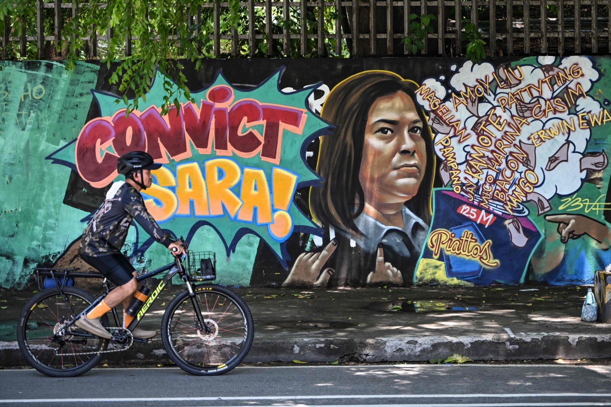 A man cycles past a mural at the University of the Philippines in Quezon City on June 3, calling for the conviction of Vice-President Sara Duterte-Carpio. Photo: AFP A man cycles past a mural at the University of the Philippines in Quezon City on June 3, calling for the conviction of Vice-President Sara Duterte-Carpio. Photo: AFP