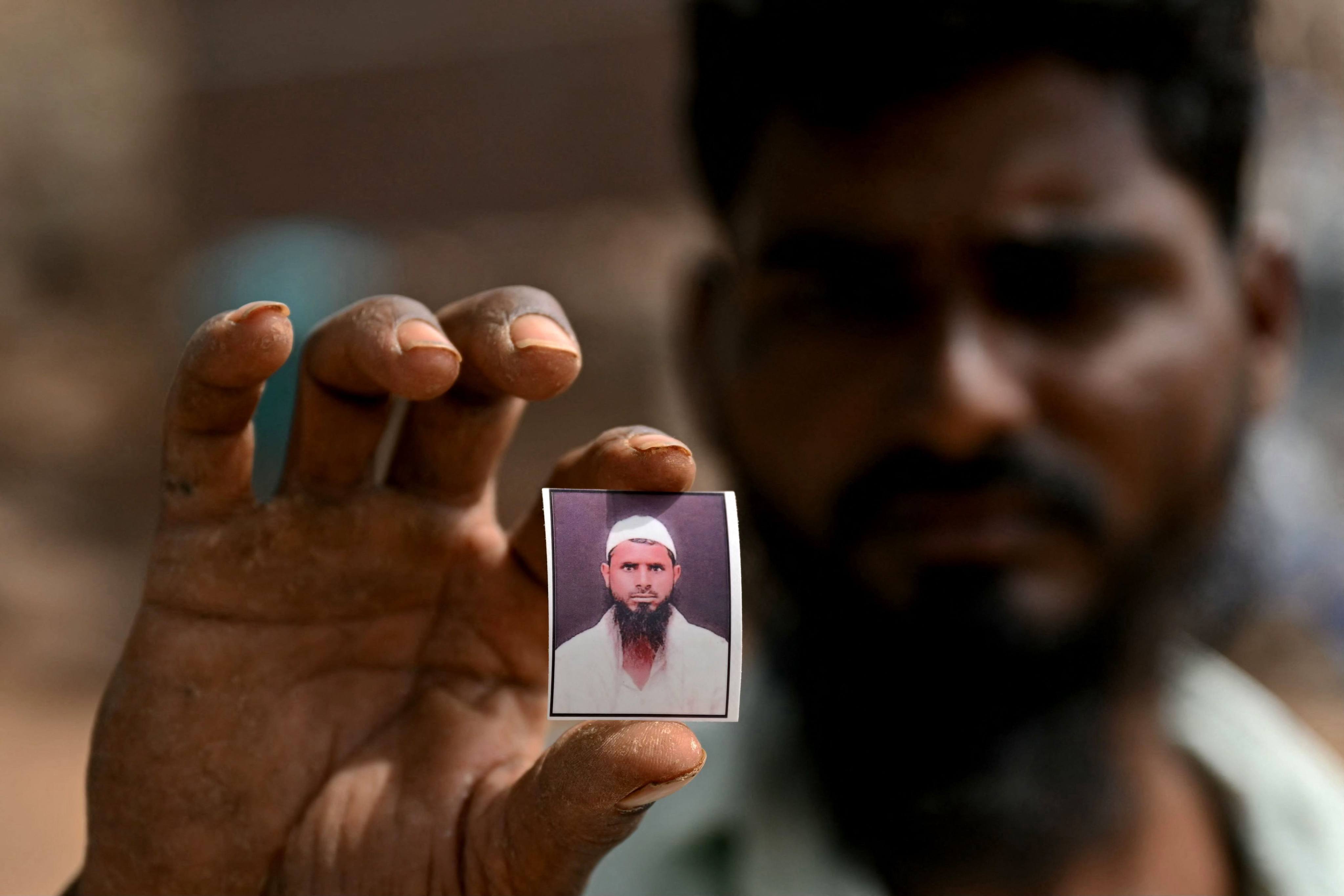 Shaikh Imran shows a photo of his brother Shaikh Latif Sheru, a farmer who committed suicide due to mounting financial loans. Photo: AFP