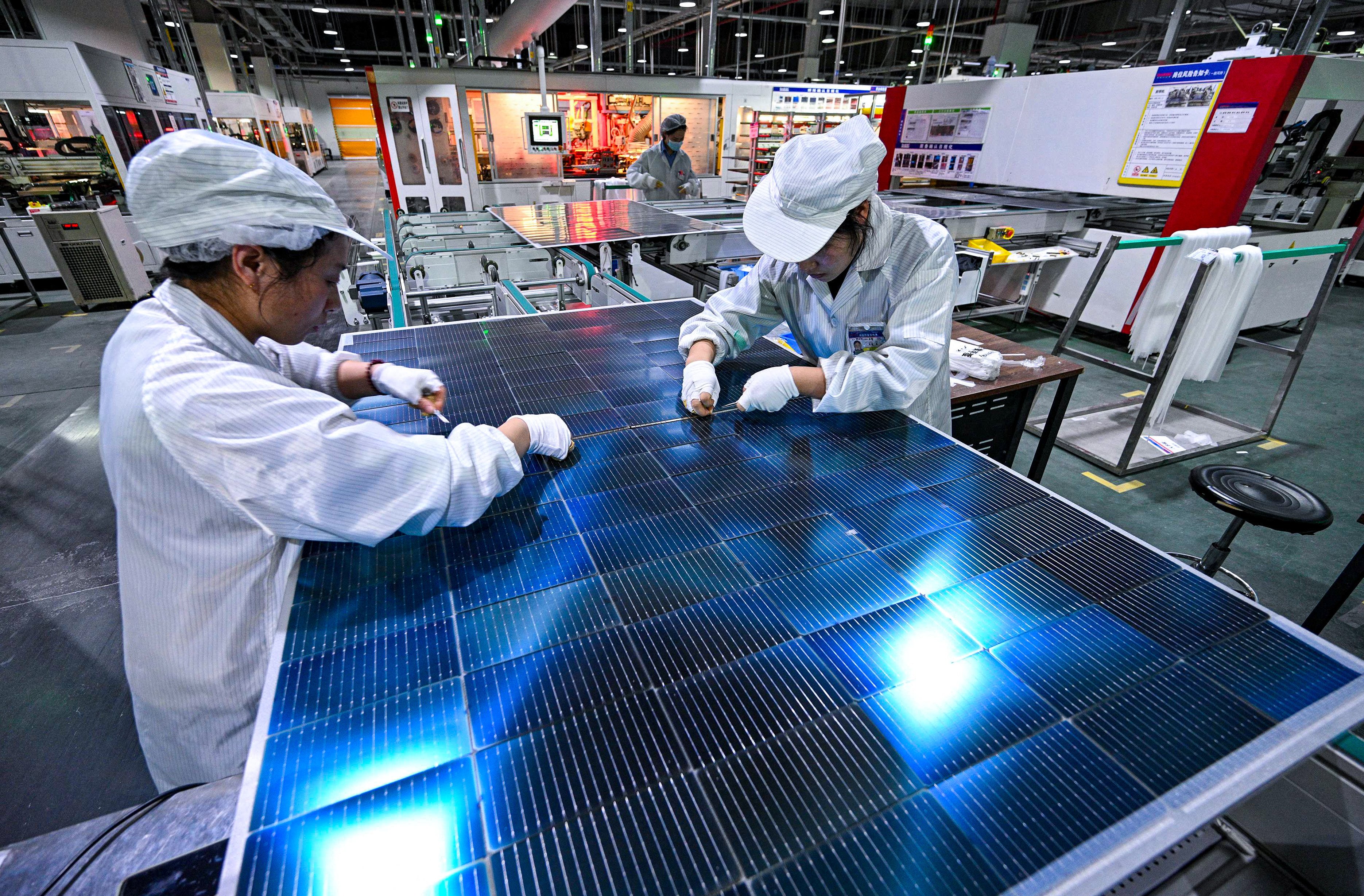 Workers producing photovoltaic modules for solar panels in a factory in Suqian, Jiangsu province in January 2025. Photo: AFP