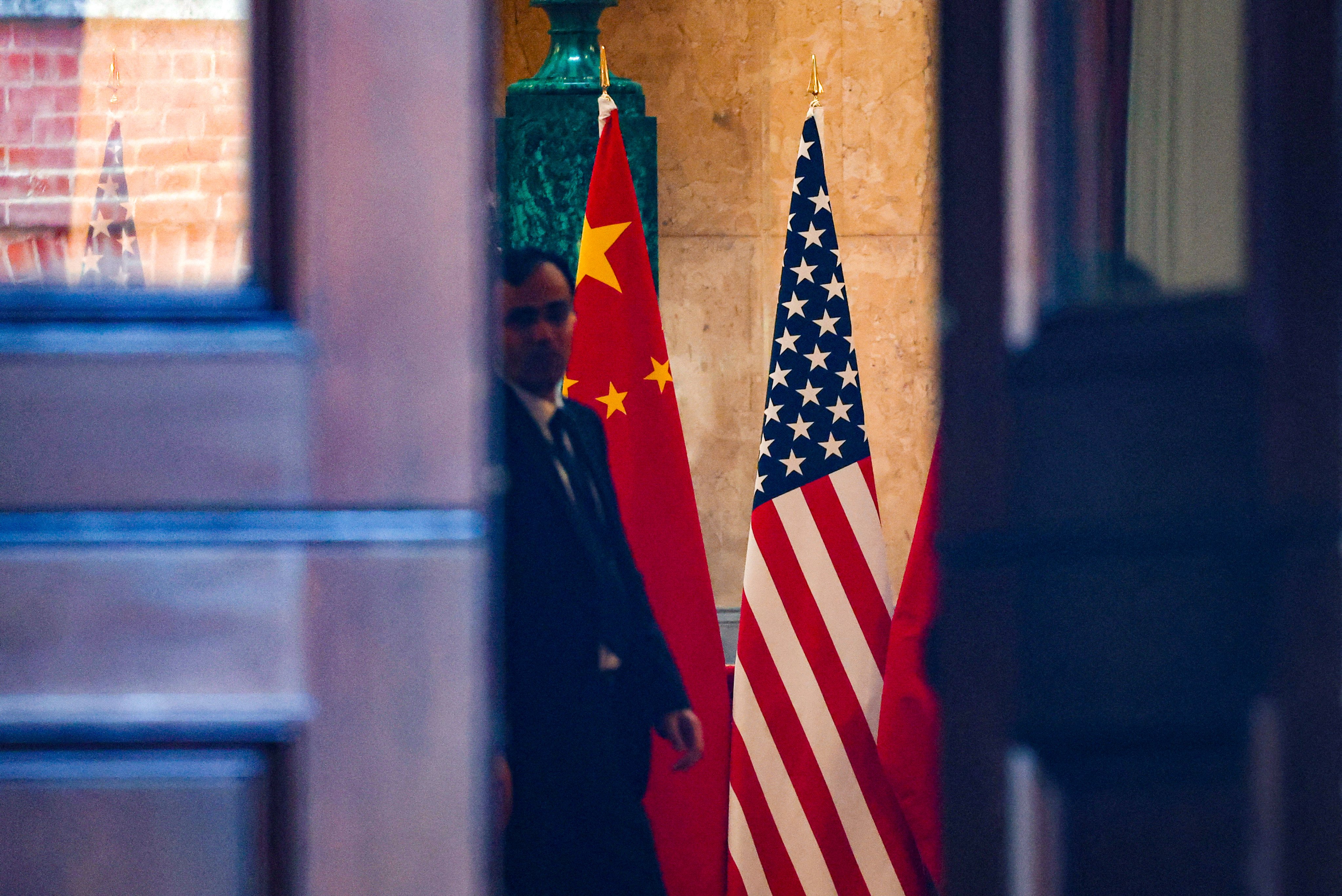 A man stands next to US and China flags at Lancaster House in London on Tuesday for the second day of trade talks between the US and China. Photo: Reuters