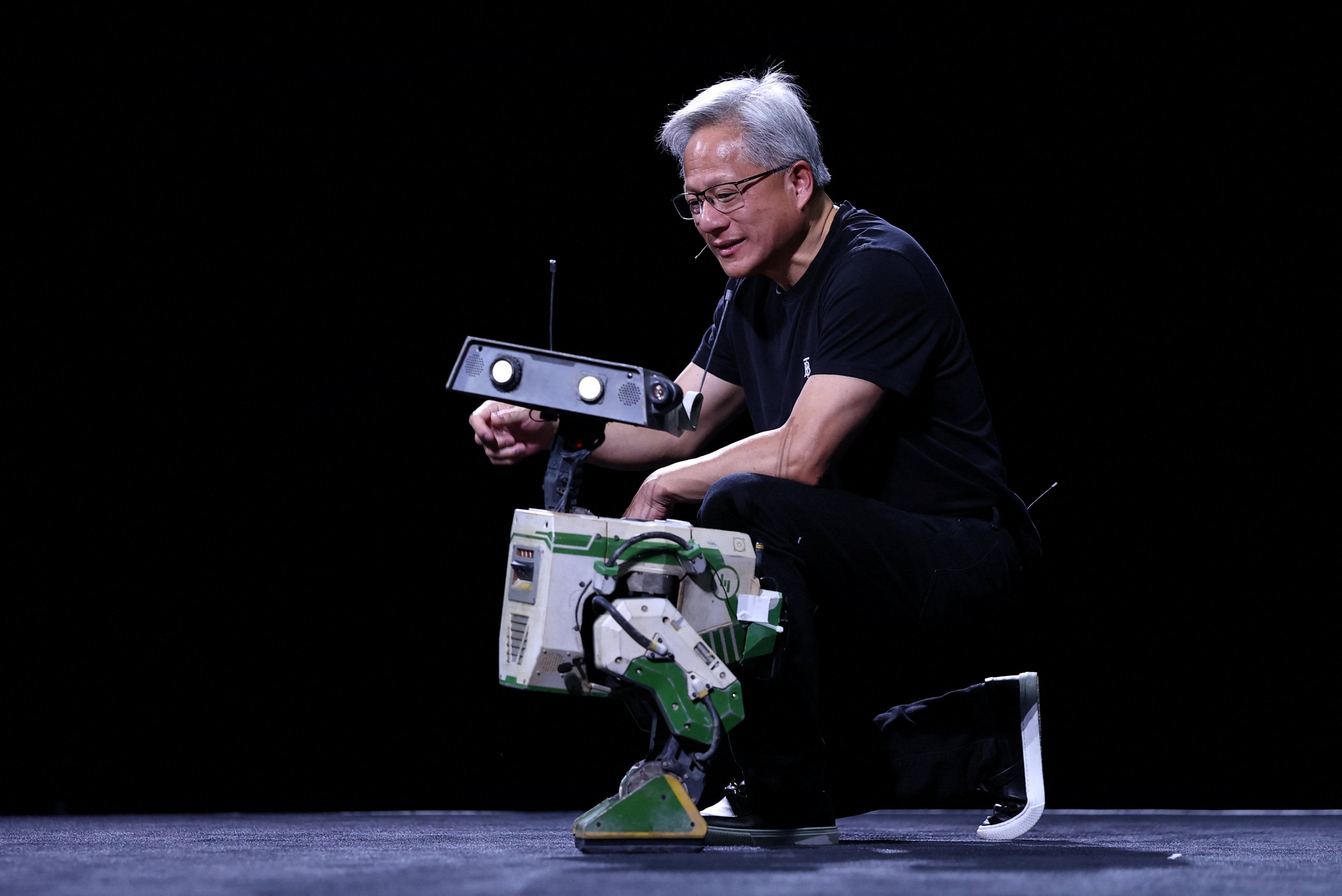 Nvidia CEO Jensen Huang interacts with a small robot during his VivaTech presentation in Paris on June 11. Photo: Reuters