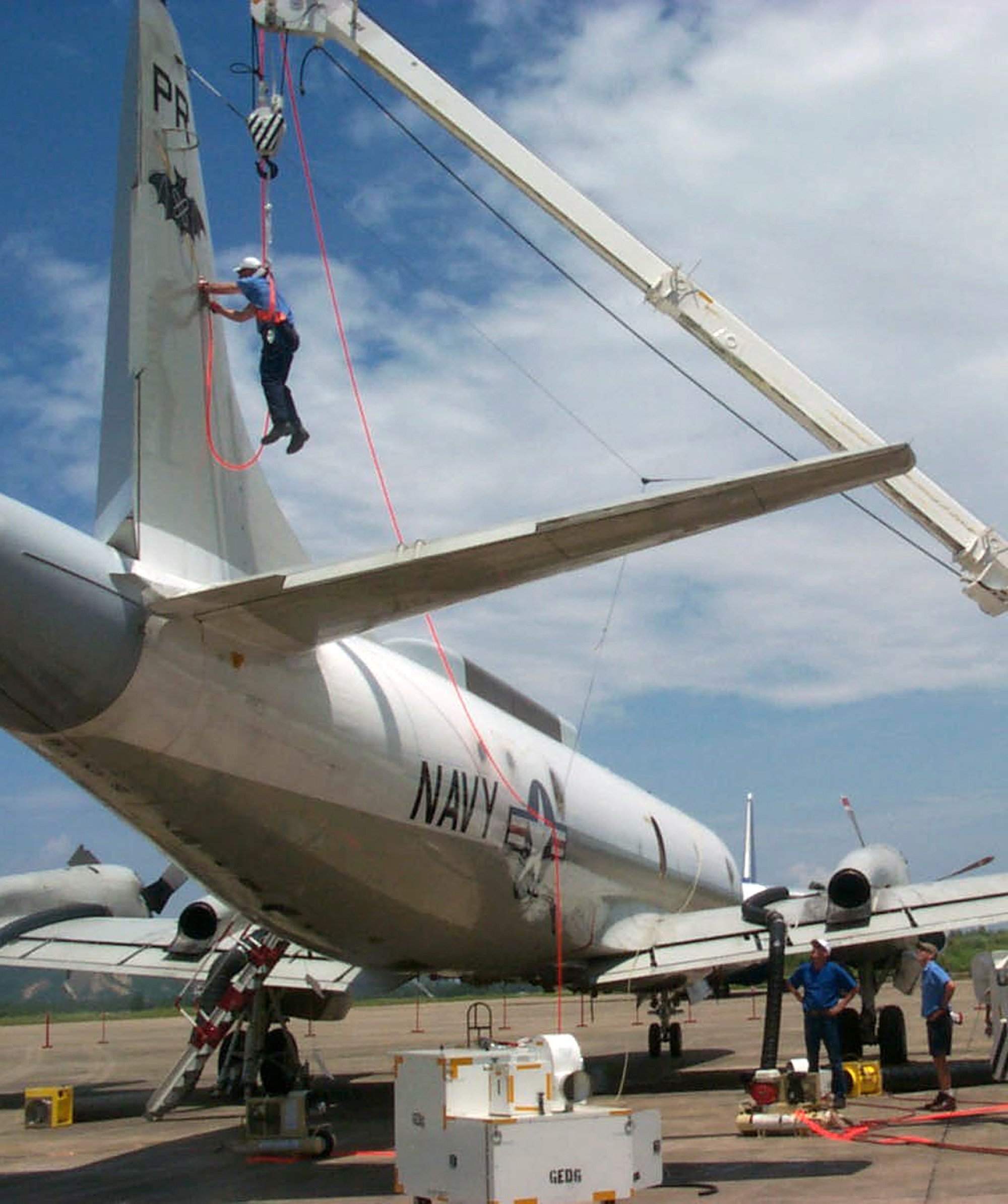 A Lockheed Martin Aeronautics recovery team member hangs from a crane as he works to remove the dorsal fin of the US Navy EP-3 surveillance plane at the Lingshui airfield on China’s Hainan island on June 22, 2001. The plane collided in midair with a Chinese F-8 fighter plane on April 1, 2001. Photo: Reuters/Lockheed Martin Aeronautics
