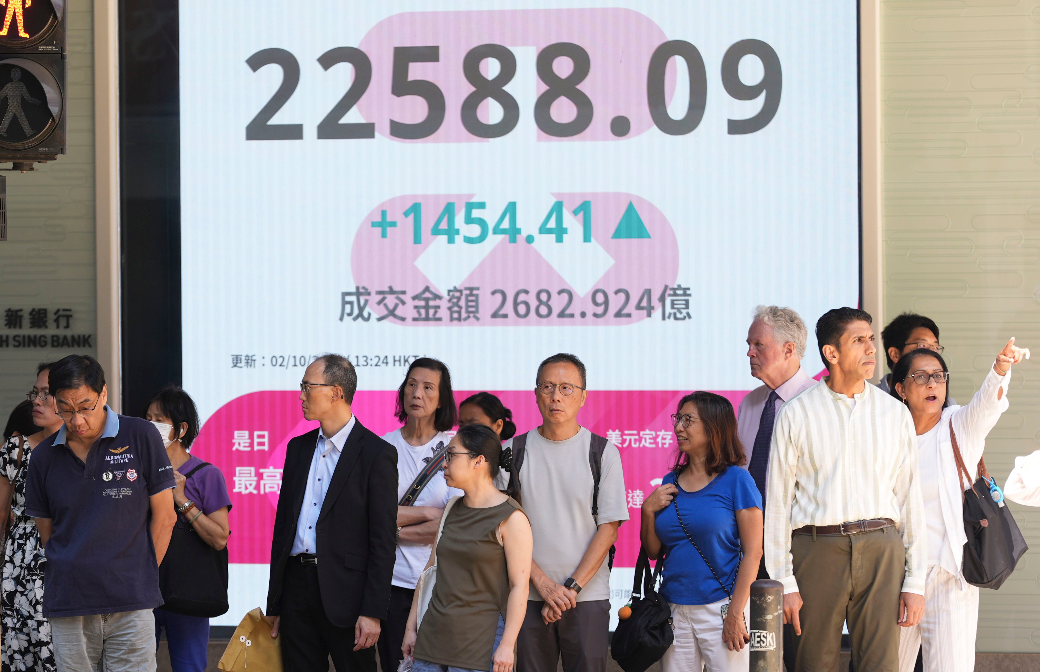 People in Central district stand near a screen displaying stock data on October 2. Photo: Eugene Lee