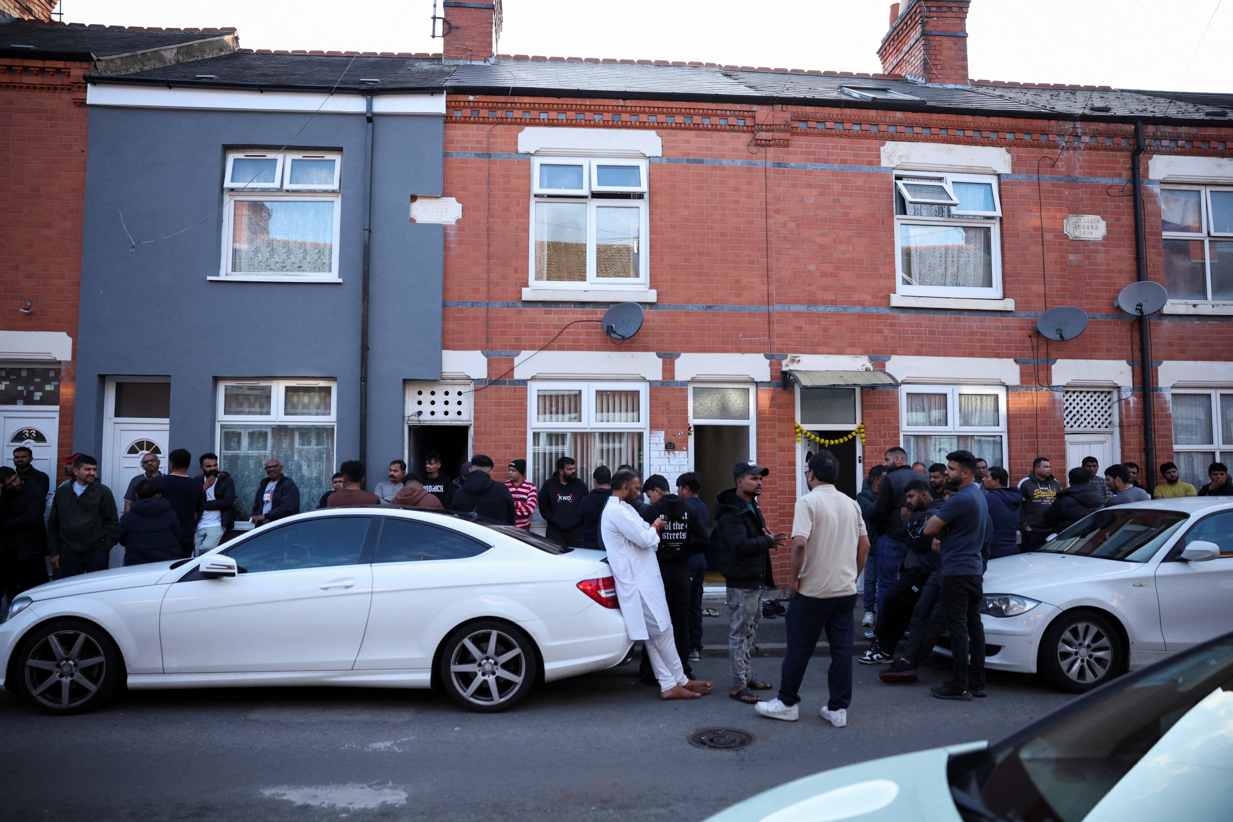 Local community members stand outside the British home of Ramesh Vishwaskumar, who survived the Air India plane crash in Ahmedabad. Photo: Reuters