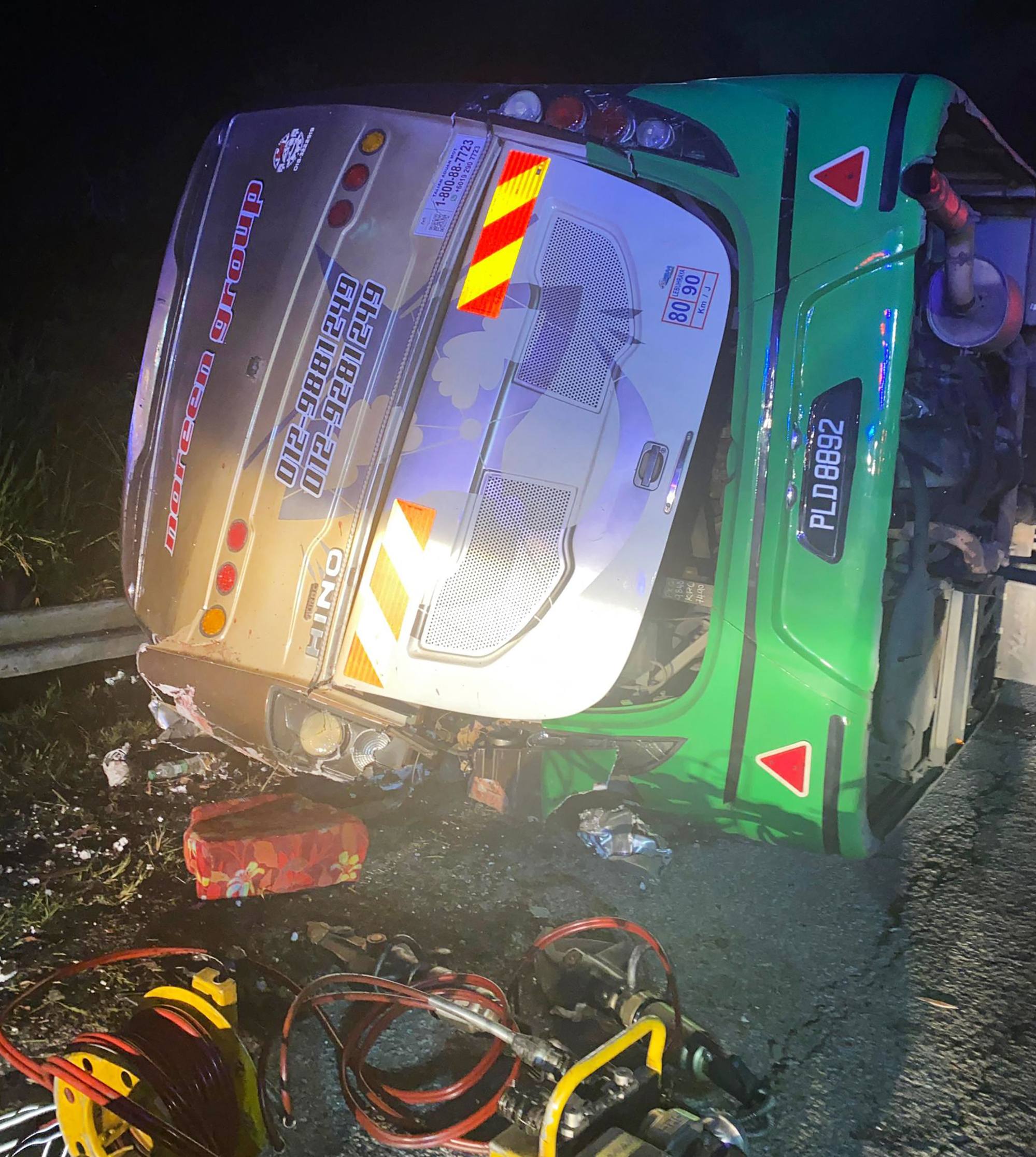 A bus lies on its side after it collided with a minivan in Malaysia’s Perak state. Photo: Perak Fire and Rescue Department/AFP