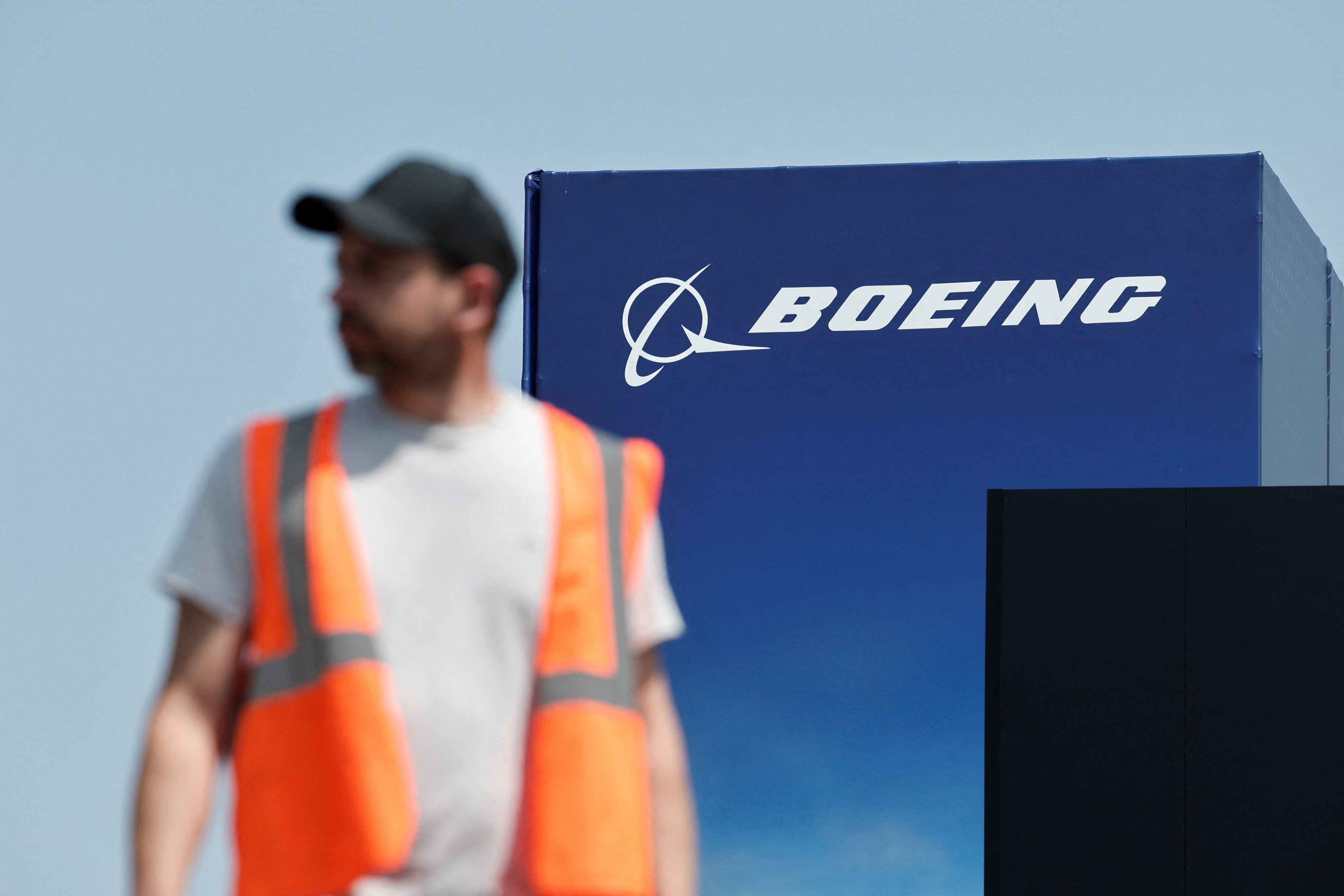 A worker walks past a Boeing logo before the opening of the 55th International Paris Airshow on Friday. Photo: Reuters