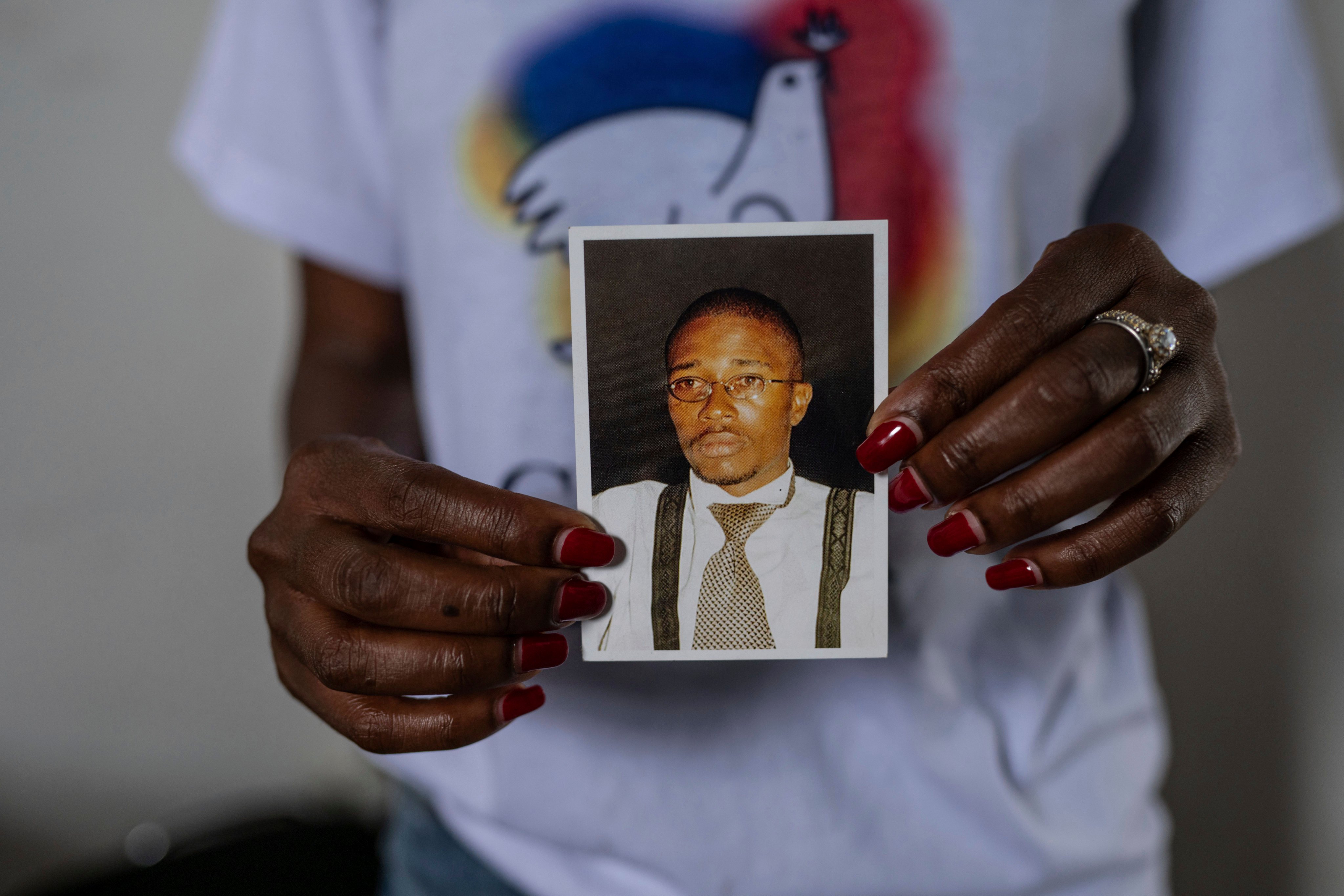 Aline Minani holds a photo of Floribert Bwana Chui Bin Kositi, a Congolese man killed in 2007 for fighting corruption, and whose beatification was approved by Pope Francis, in Goma, Democratic Republic of Congo, on December 29 last year. Photo: AP