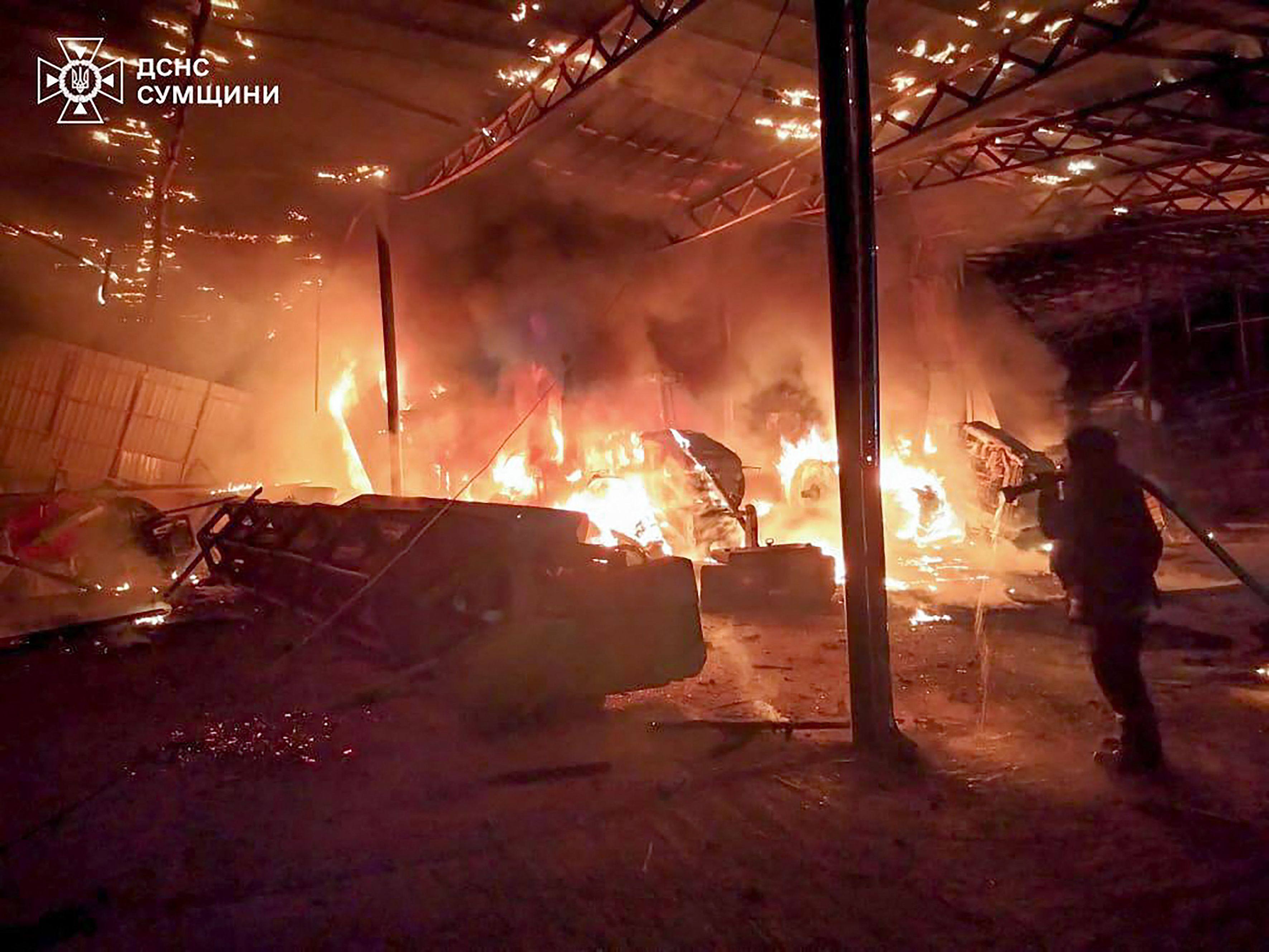 A Ukrainian rescuer works to extinguish a fire at the site of a drone attack in the Sumy region on June 11. Photo: AFP