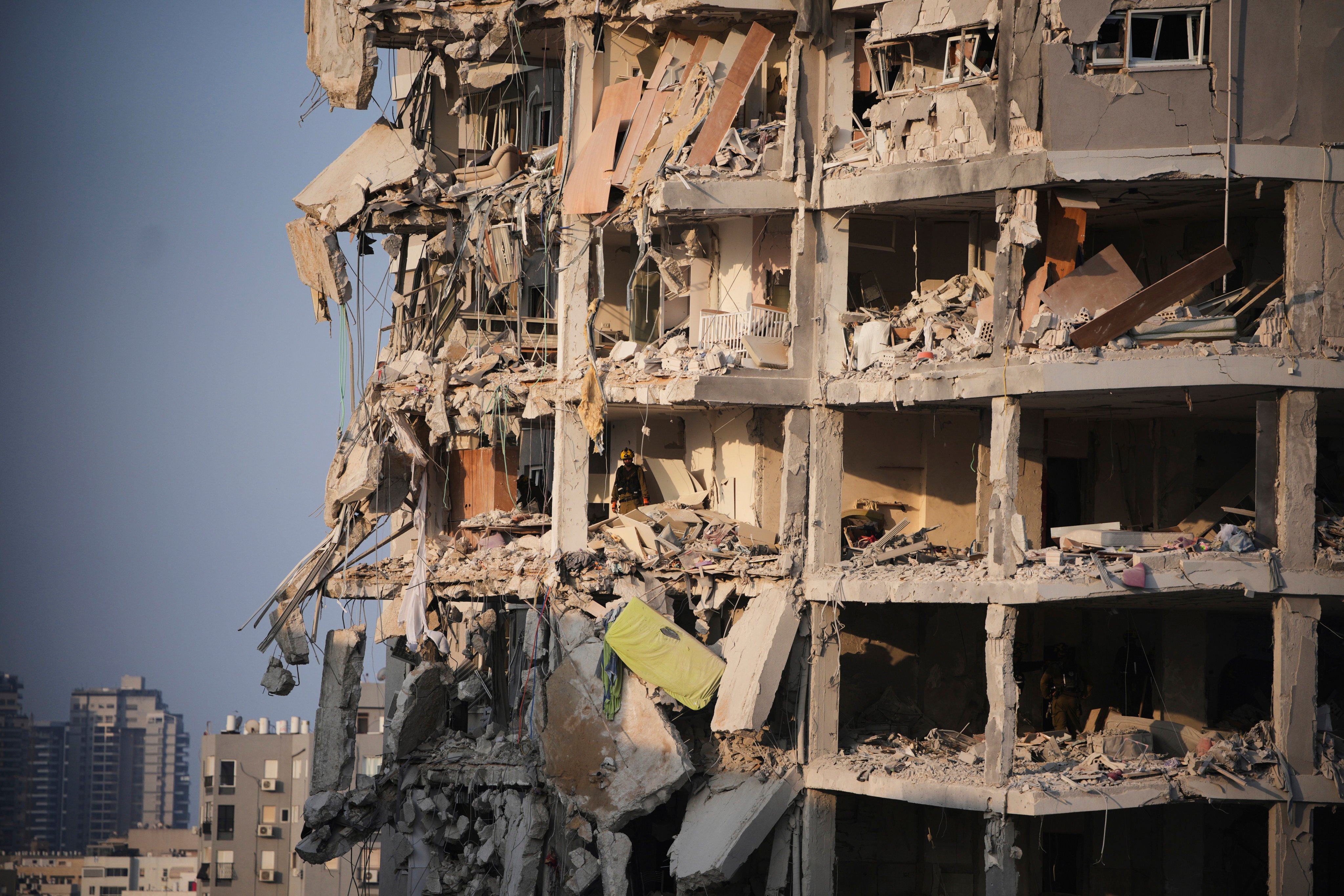 Israeli security forces inspect a destroyed building that was hit by a missile fired from Iran, near Tel Aviv, Israel. Photo: AP