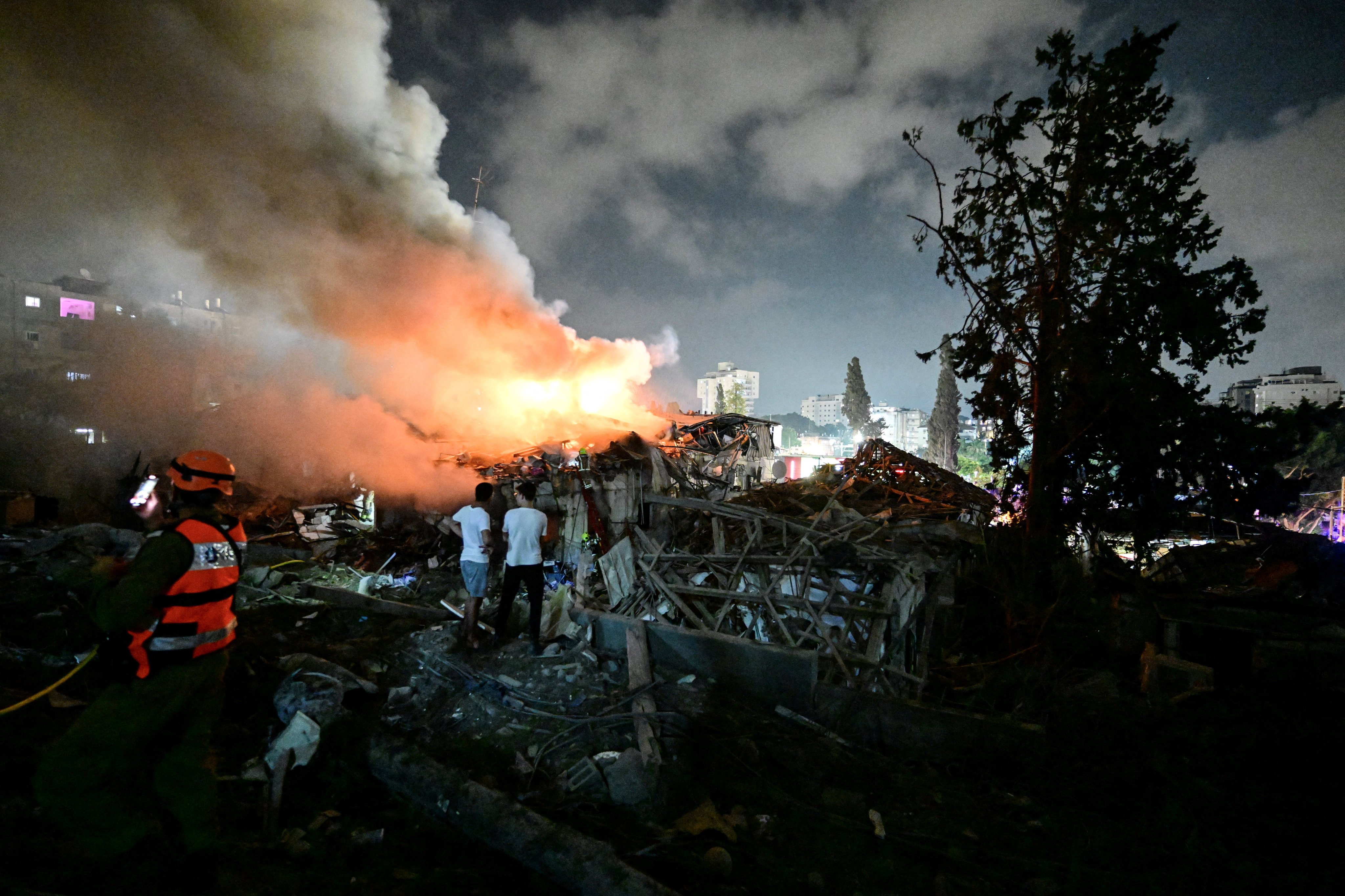 Locals look at the fire at a site following missile attack from Iran on Israel on Sunday. Photo: Reuters