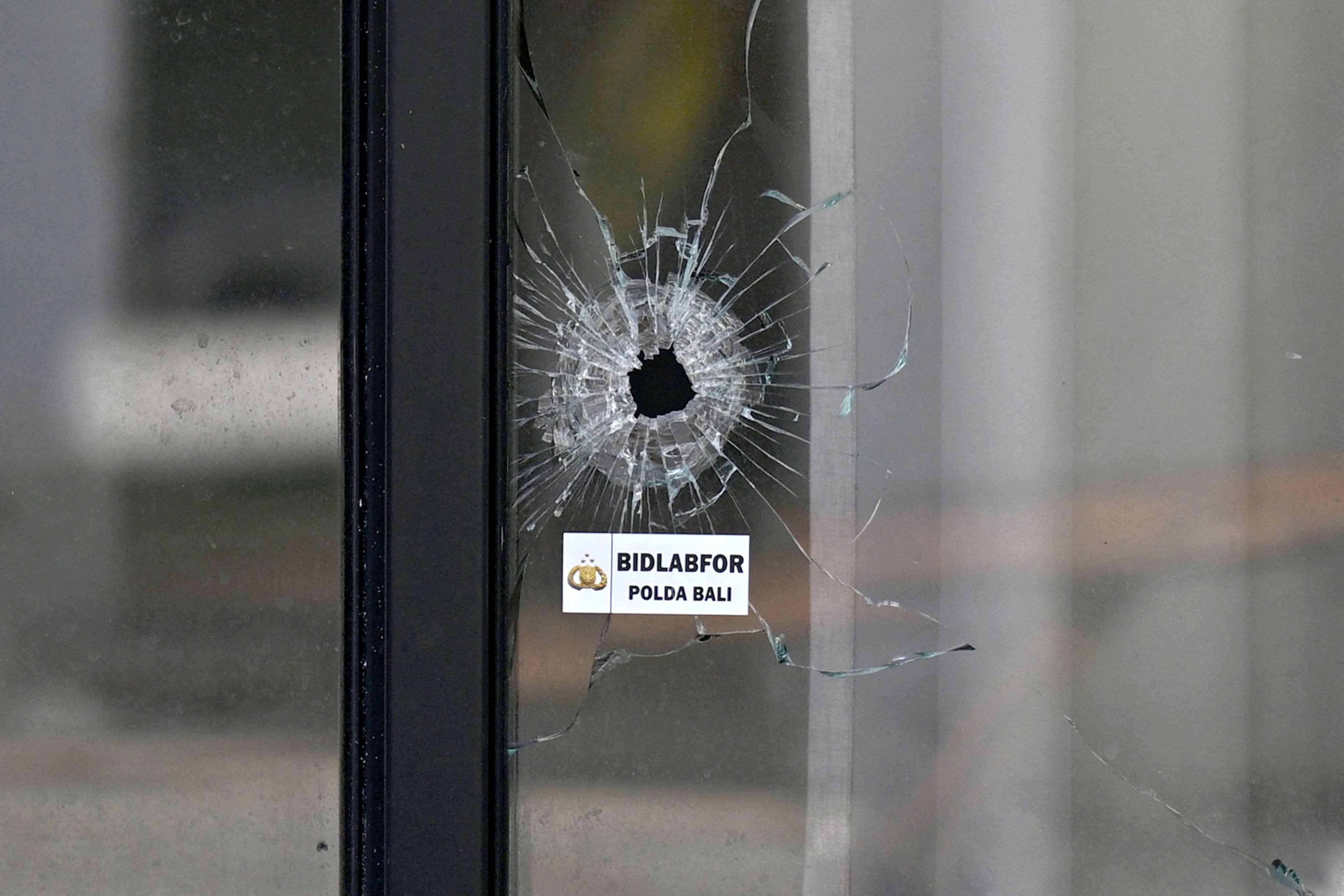 A bullet hole is seen in the glass door of a villa in Bali where one Australian was shot dead and another wounded. Photo: AFP