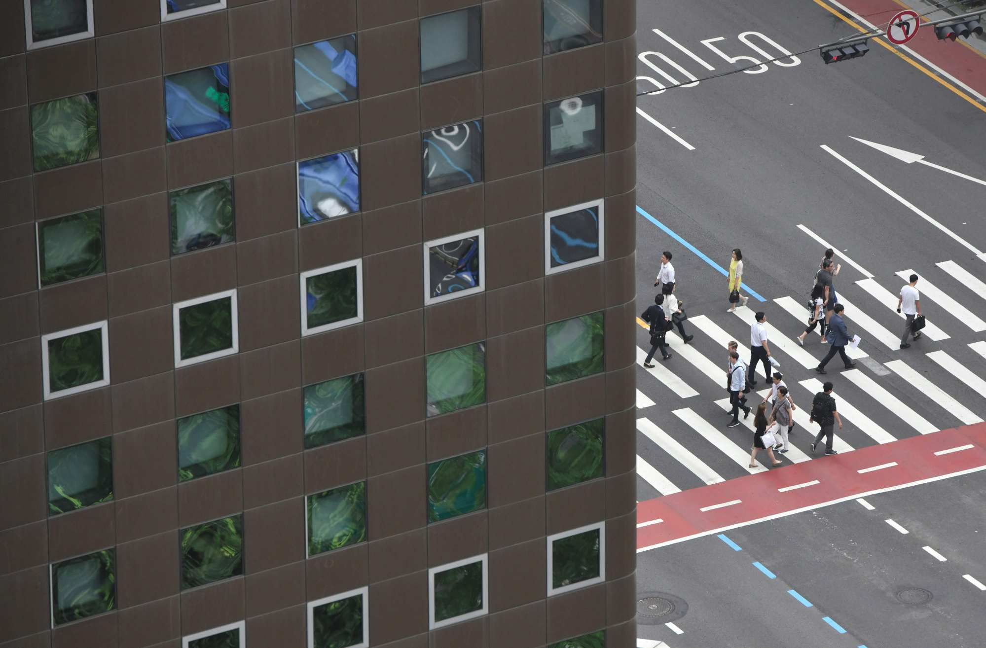 People walk across a road in Seoul’s business district in July 2019. Photo: AFP People walk across a road in Seoul’s business district in July 2019. Photo: AFP