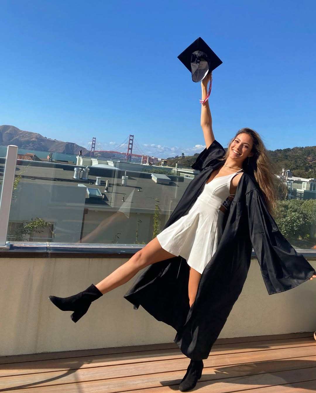 Chinese-American freestyle skiing world champion Eileen Gu wears a white fitted dress beneath her graduation gown for her high school graduation in 2020. Photo: Instagram/eileengu