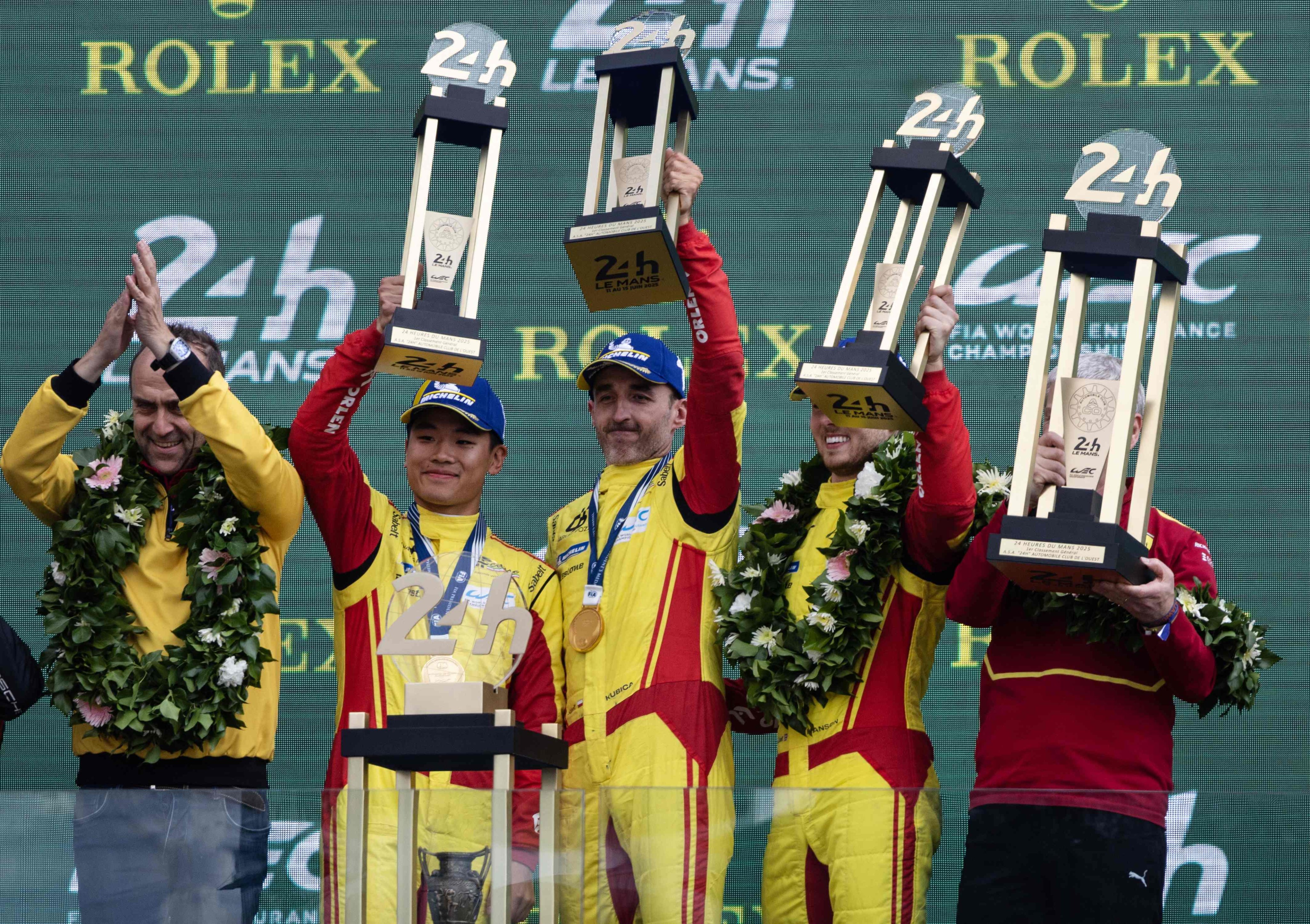 AF Corse drivers (from left) Ye Yifei, Robert Kubica and Philip Hanson lift their trophies at the Le Mans circuit on Sunday. Photo: AFP