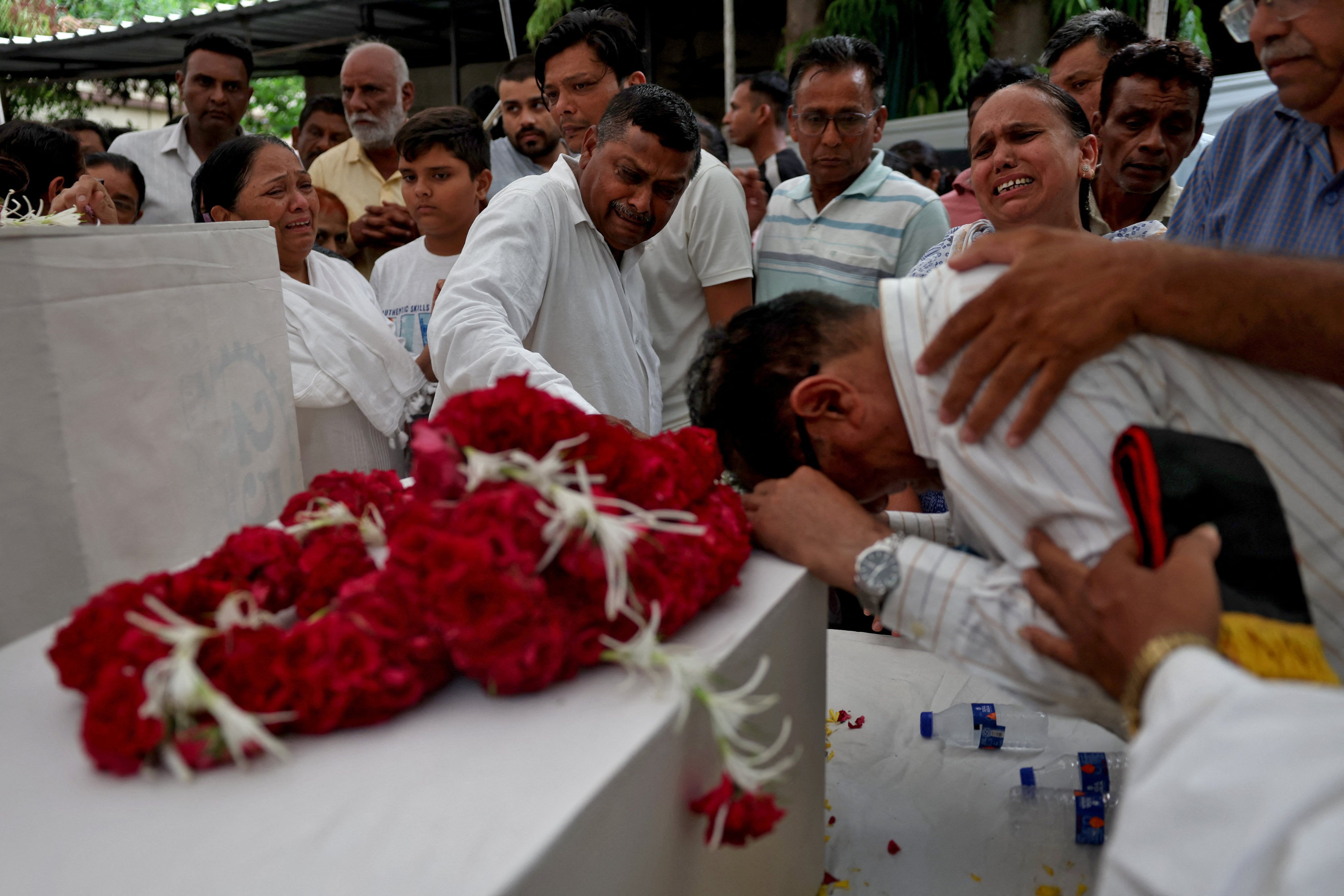 Relatives in Ahmedabad on Sunday react next to the coffins of passengers who lost their lives in the Air India plane crash. Photo: Reuters