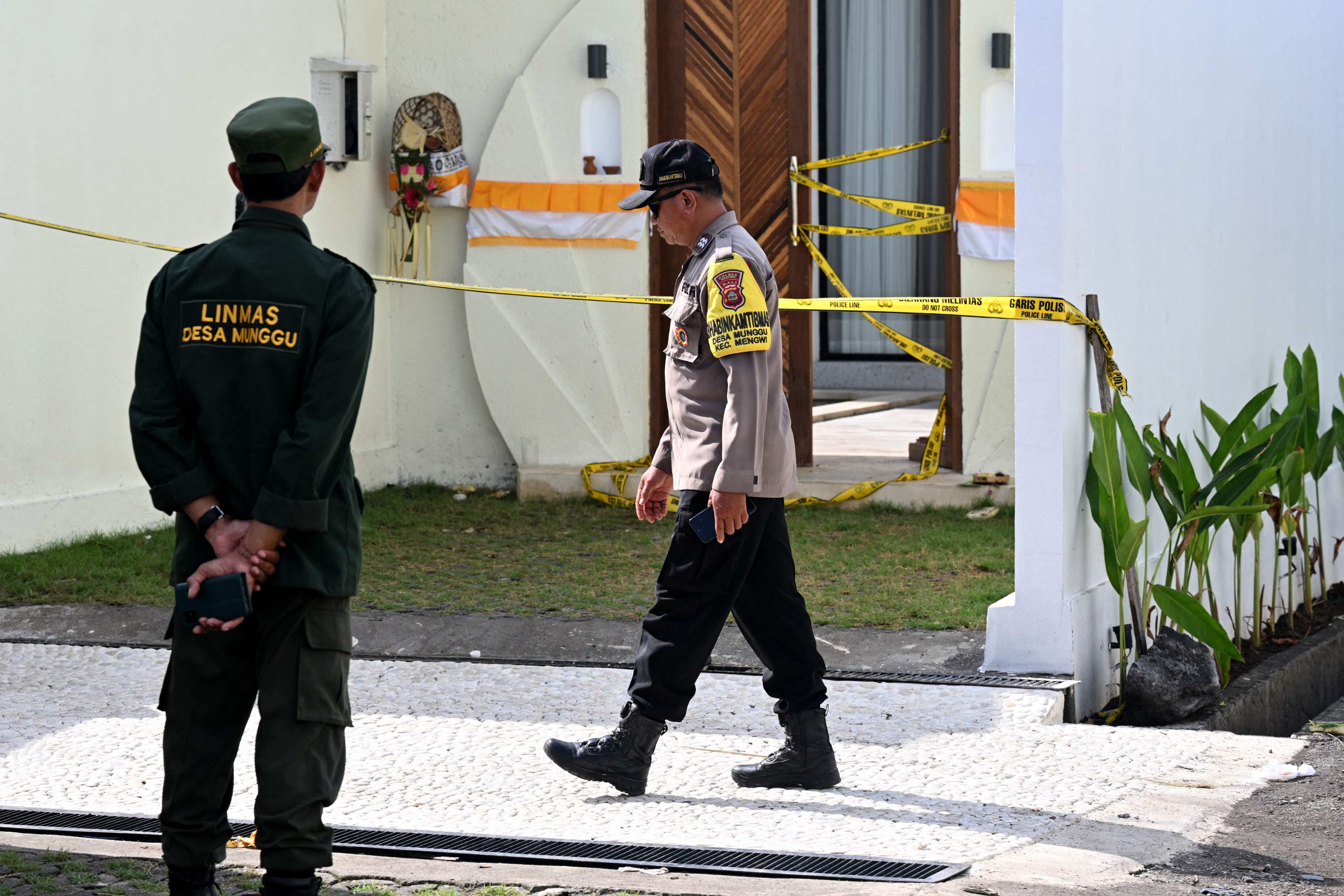 A police officer walks past the villa in Bali where one Australian was shot dead and another wounded at the weekend. Photo: AFP