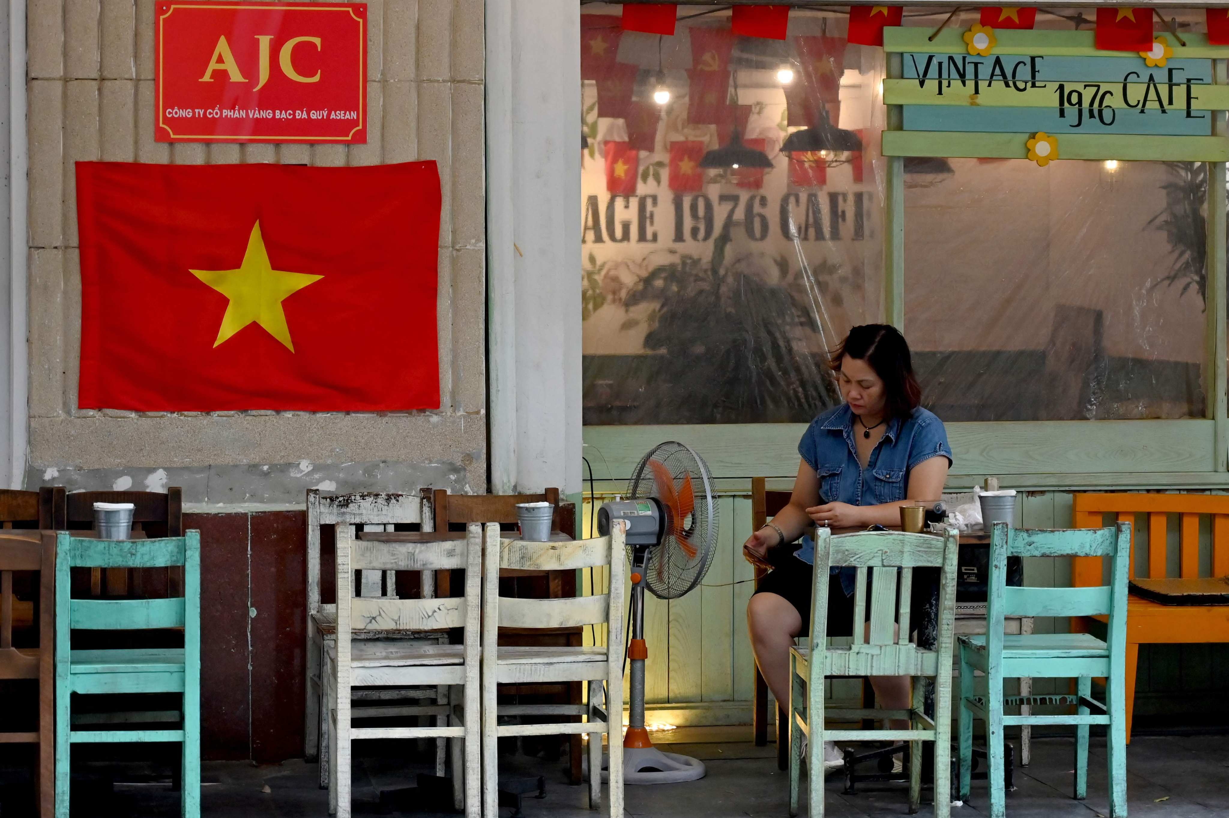 A woman uses her smartphone in a coffee shop in Hanoi. Photo: AFP