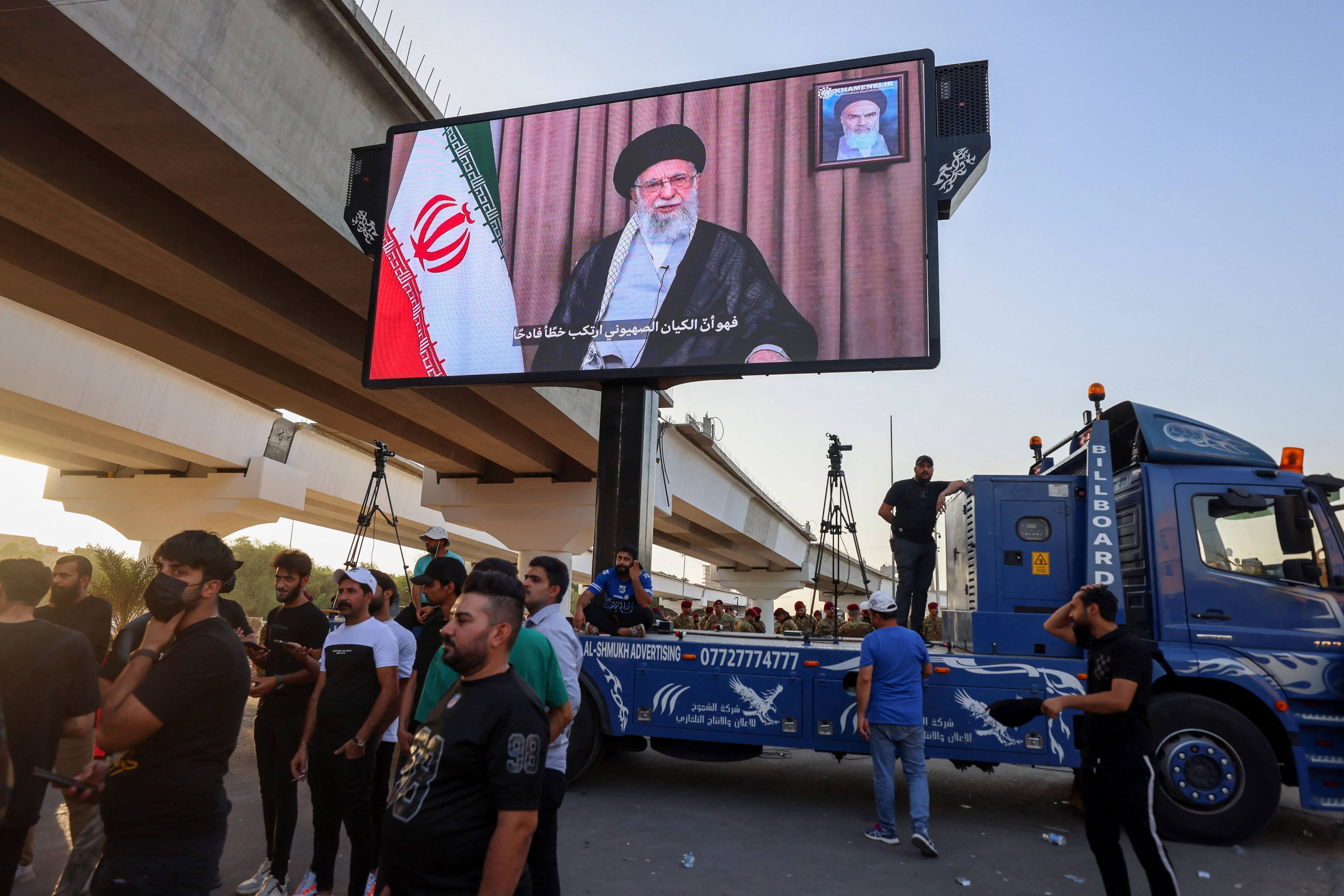 Supporters of Iraqi pro-Iran groups wheel a screen displaying Iran’s supreme leader, Ayatollah Ali Khamenei, during a protest in Baghdad on Monday. Photo: AFP