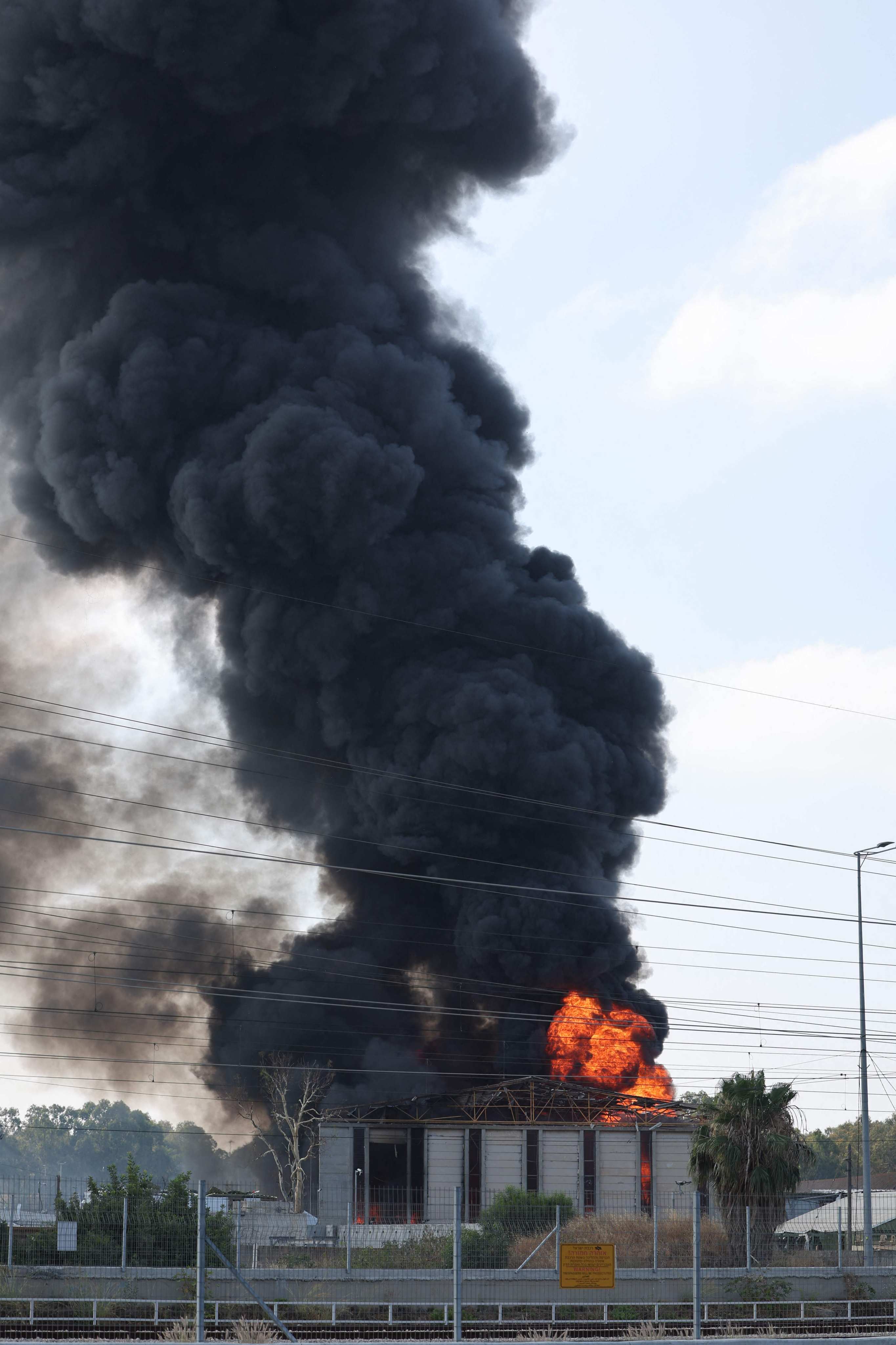 Smoke billows from a building in Israel’s Herzliya near Tel Aviv following a fresh barrage of Iranian rockets on Tuesday. Photo: AFP