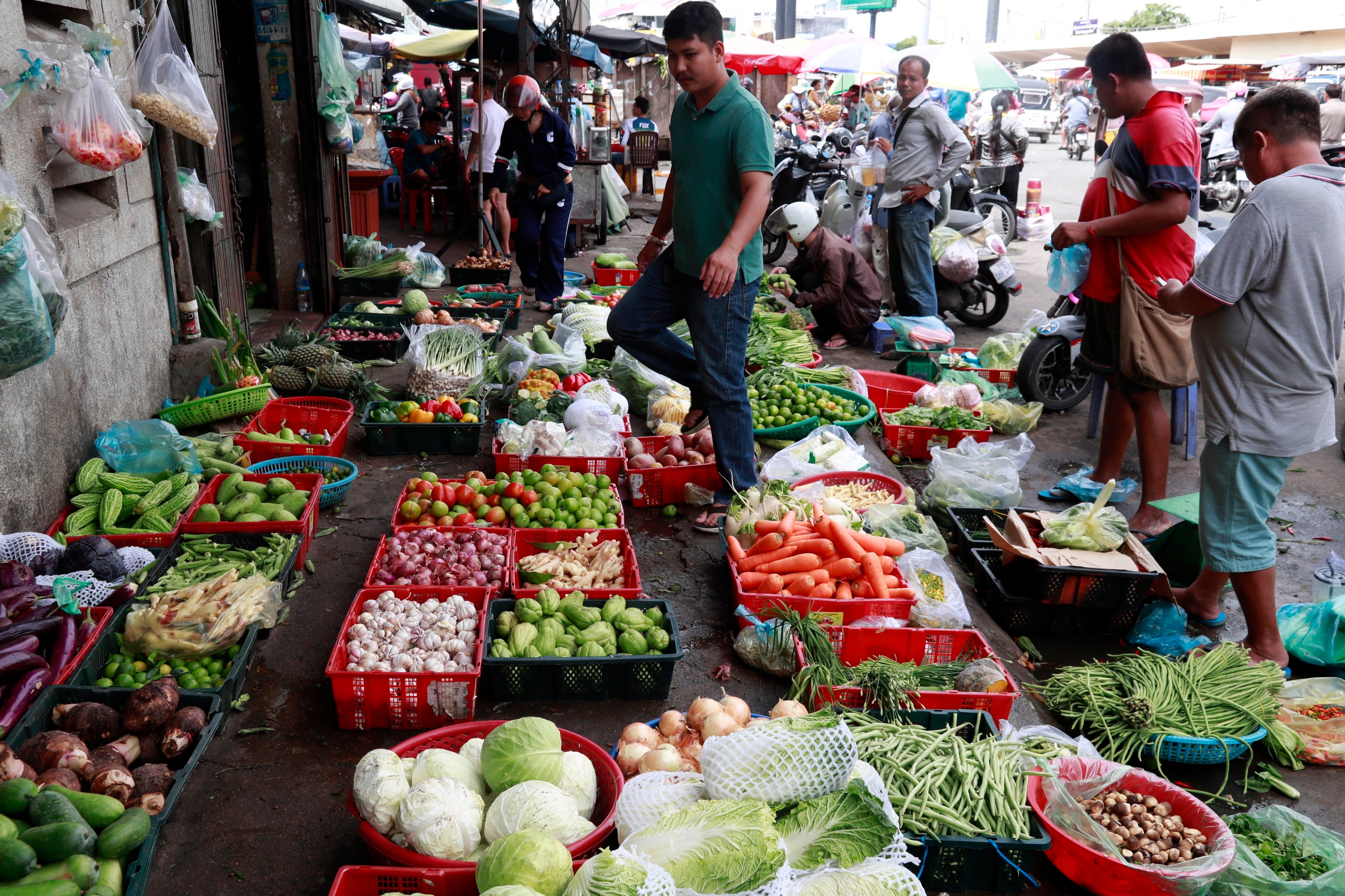People buy vegetables at a market in Phnom Penh, Cambodia, earlier this month. Photo: EPA-EFE