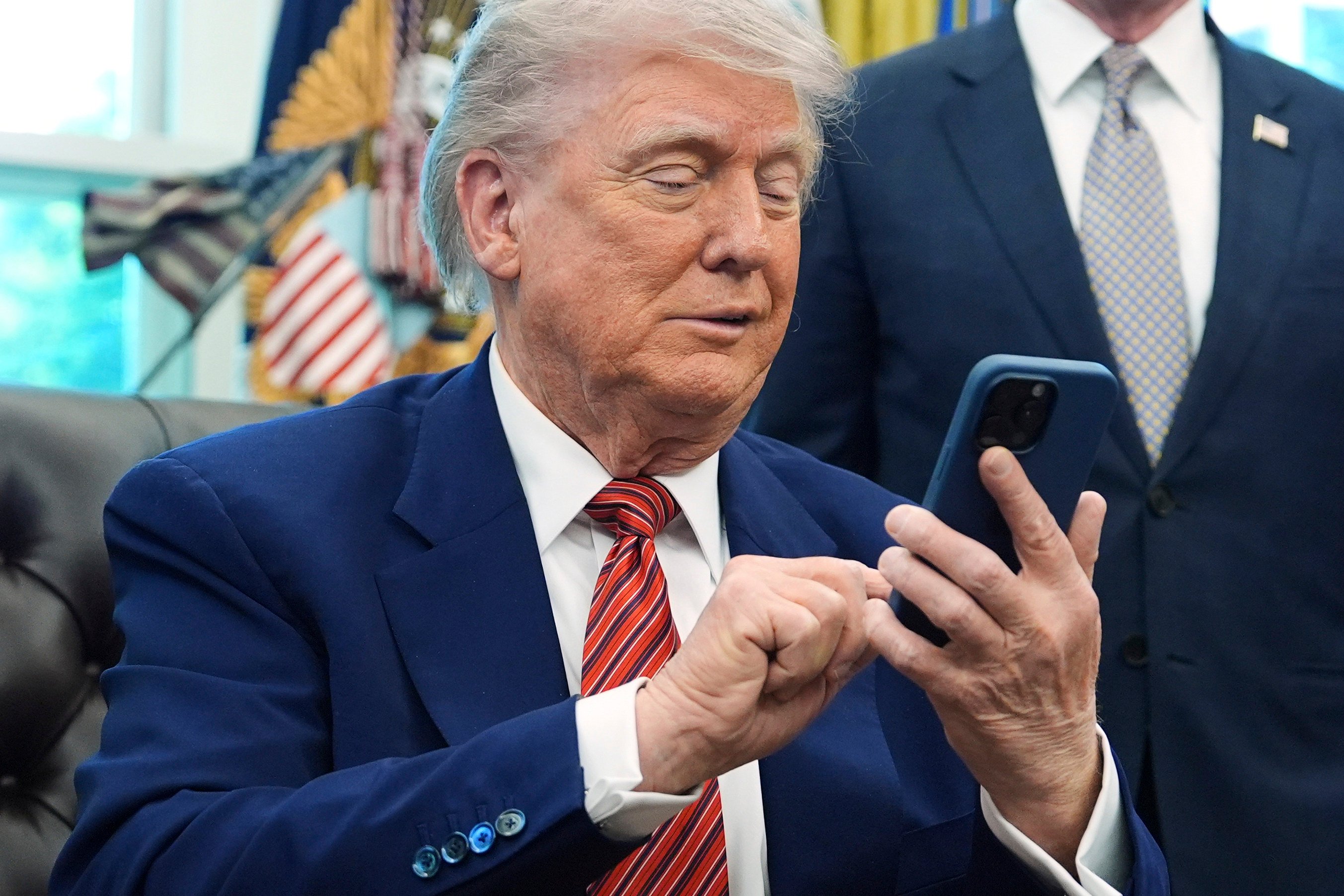 US President Donald Trump uses his mobile phone in the Oval Office. File photo: AP