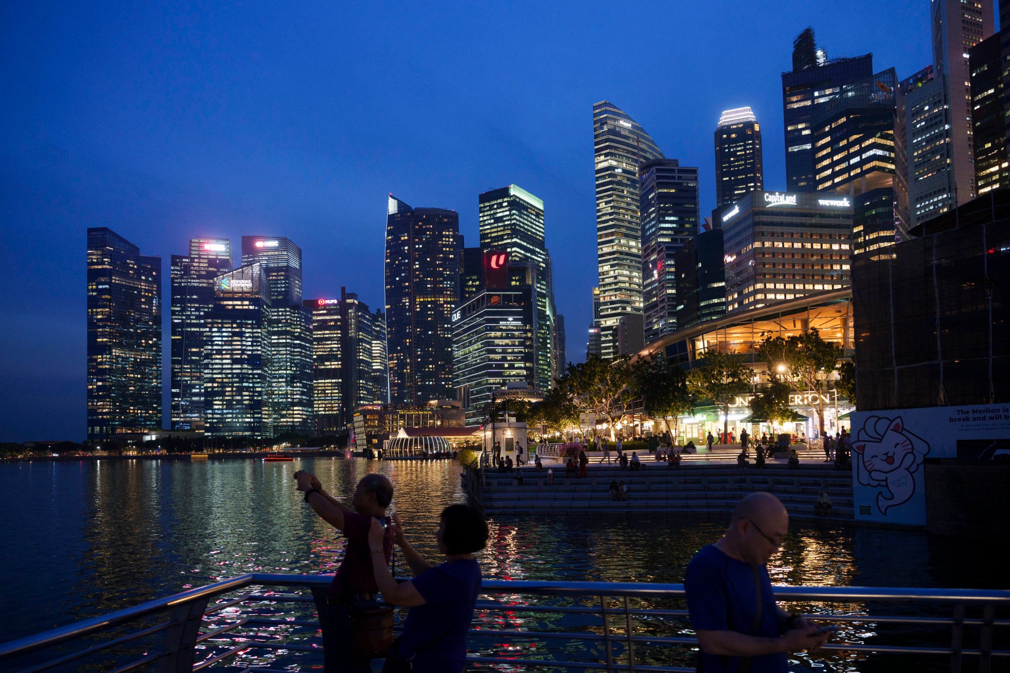 Tourists take pictures with the skyline of Singapore in 2023. Singapore’s conventional nightlife scene has struggled to recover following the pandemic. Photo: AP Tourists take pictures with the skyline of Singapore in 2023. Singapore’s conventional nightlife scene has struggled to recover following the pandemic. Photo: AP