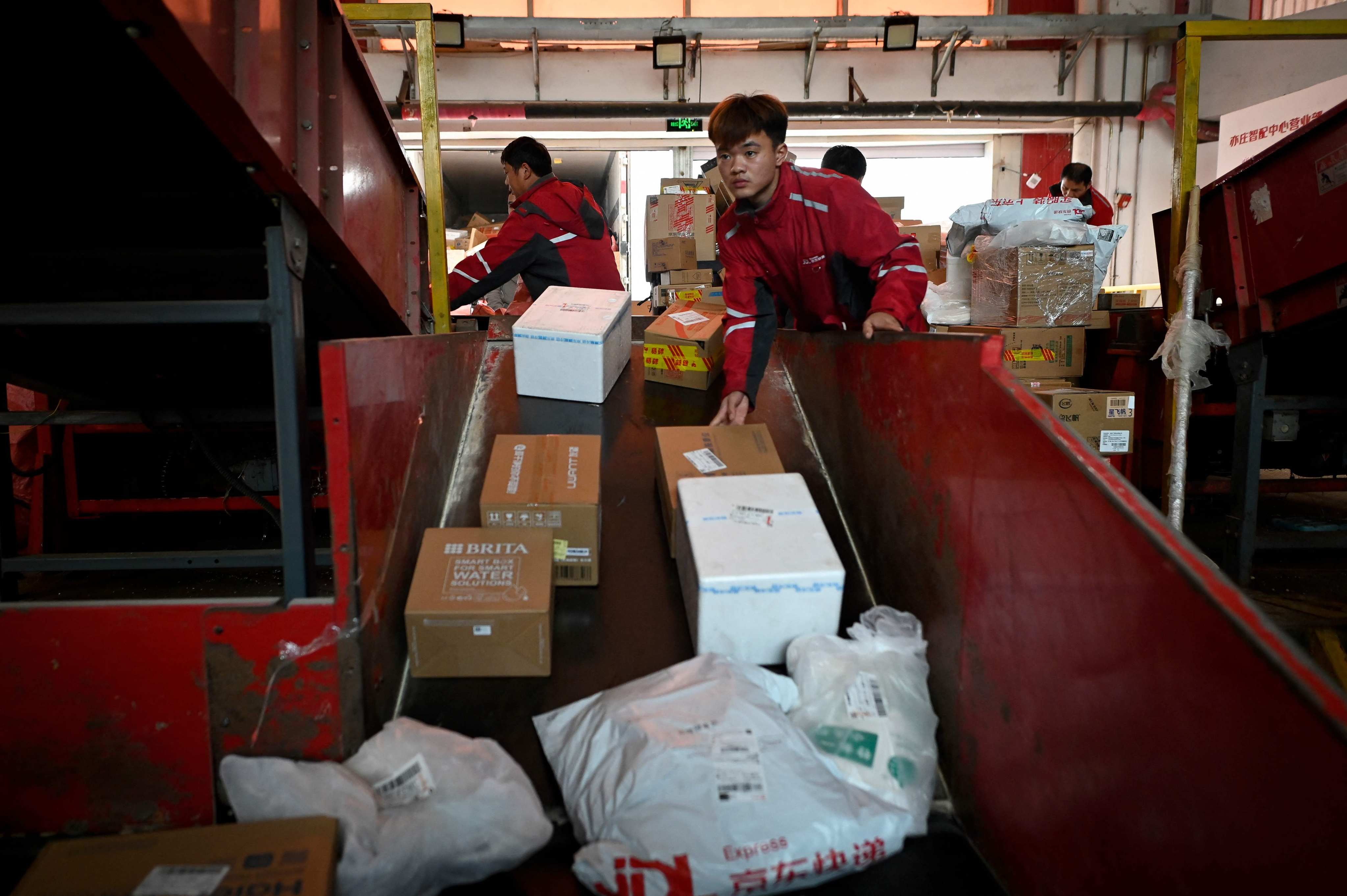 Workers sort packages for delivery at a JD.com warehouse in Beijing on November 11, 2024. Photo: AFP