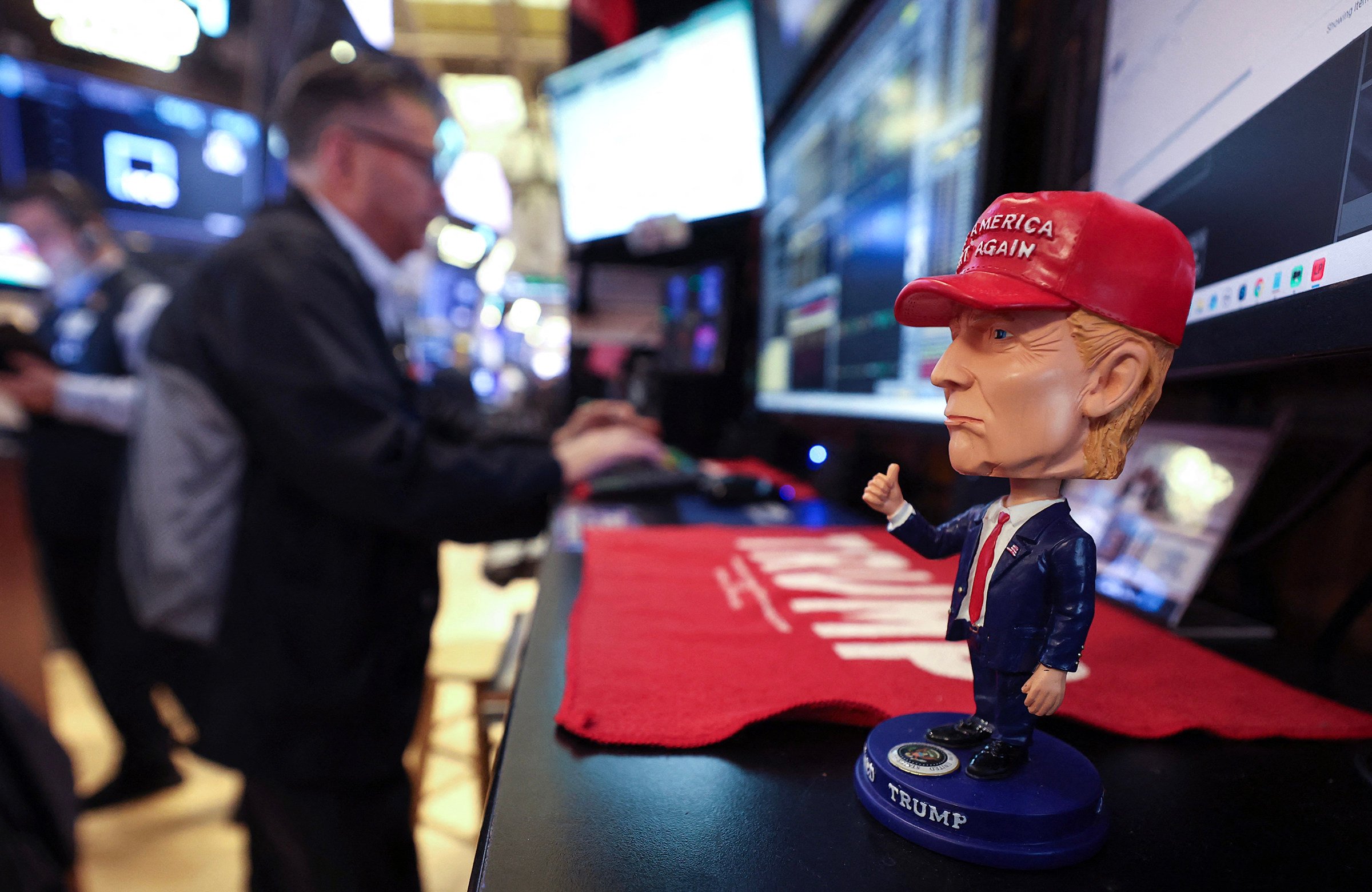 A bobble-head figurine of US President Donald Trump is seen on a desk as traders work on the floor of the New York Stock Exchange on April 14. Photo: AFP / Getty Images / TNS