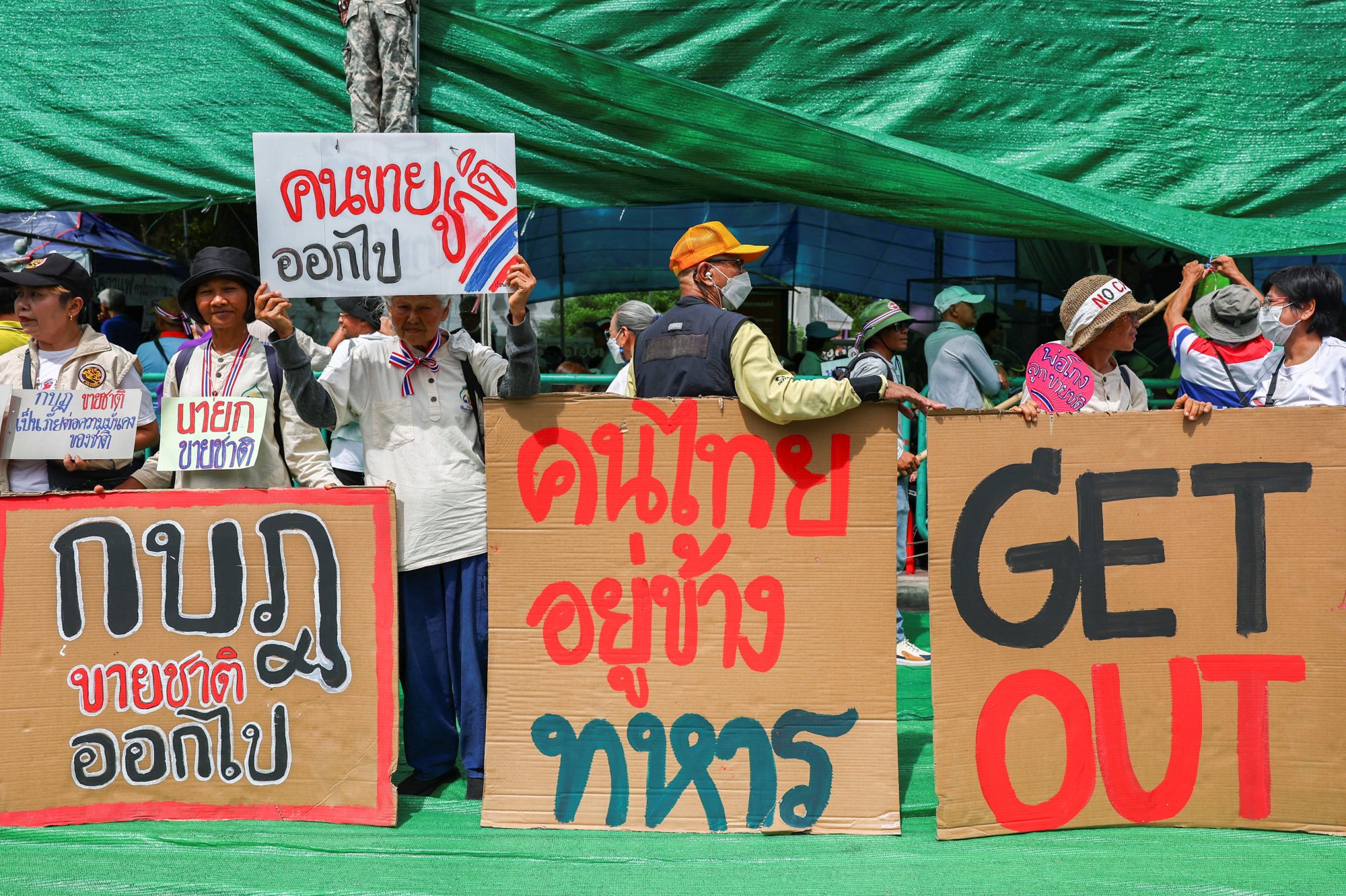 Royalist activists hold signs as they take part in an anti-government protest near Government House in Bangkok, Thailand, on Thursday. Photo: Reuters Royalist activists hold signs as they take part in an anti-government protest near Government House in Bangkok, Thailand, on Thursday. Photo: Reuters